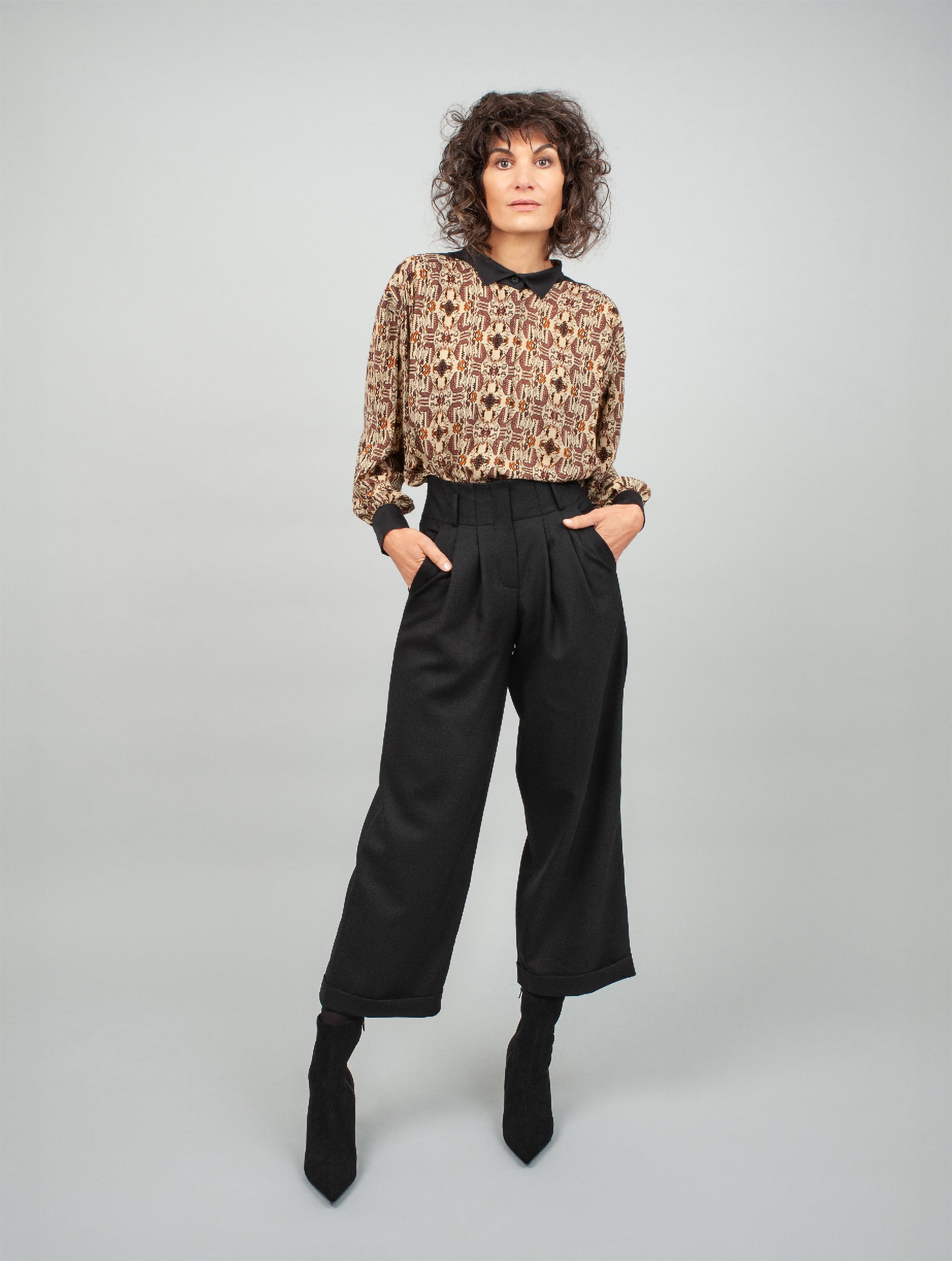 Schwarze Woll-Culotte mit hohem Bund Bundfalten, seitlichen Taschen und kleinen Aufschlägen am Hosenbein