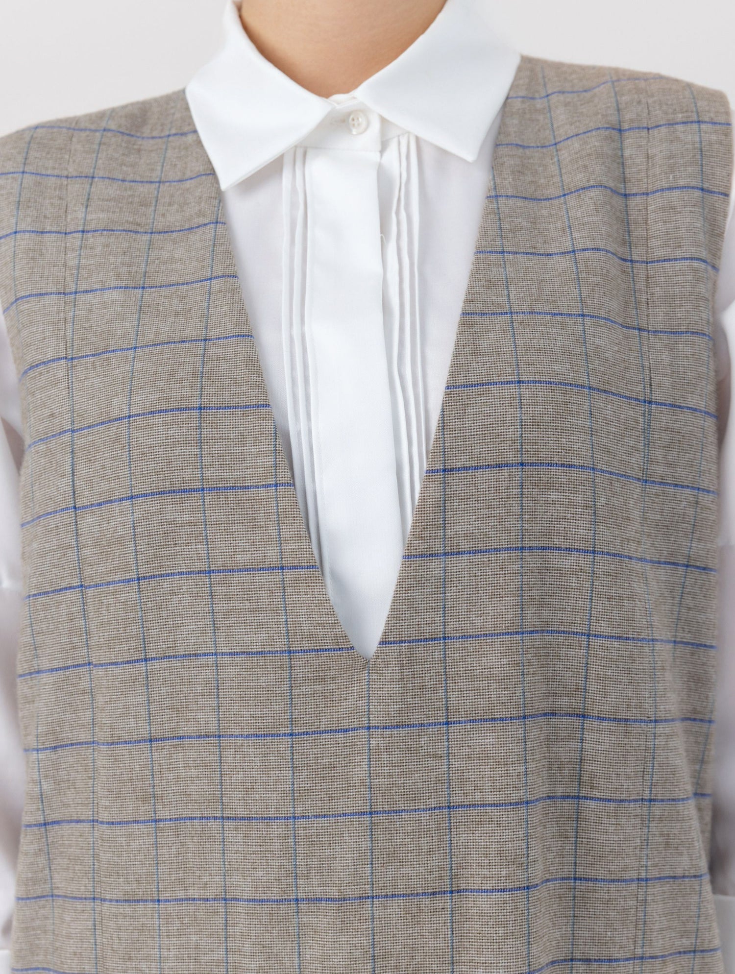 Ärmelloses, locker geschnittenes Kleid mit tiefem V-Ausschnitt und Pattentaschen sowie einem langen Seitenschlitz auf der Vorderseite. Hergestellt aus nachhaltigen Fasern.