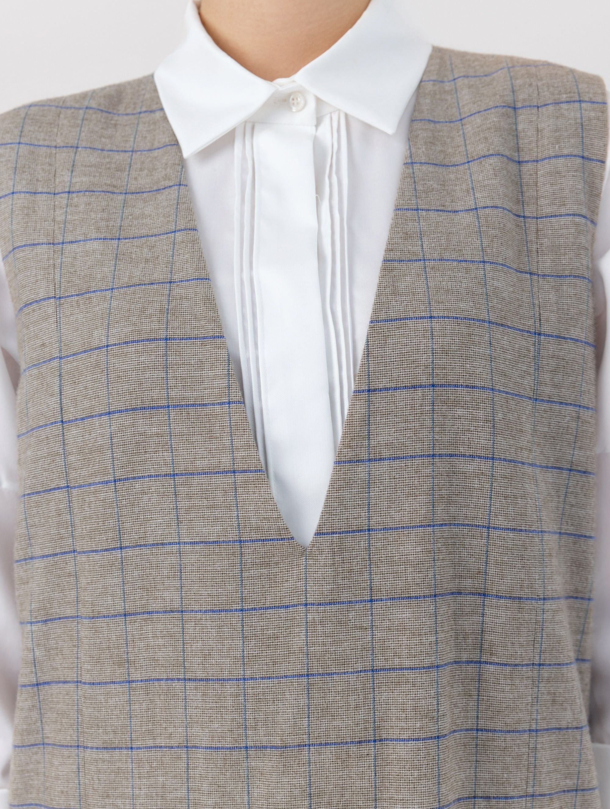 Ärmelloses, locker geschnittenes Kleid mit tiefem V-Ausschnitt und Pattentaschen sowie einem langen Seitenschlitz auf der Vorderseite. Hergestellt aus nachhaltigen Fasern.