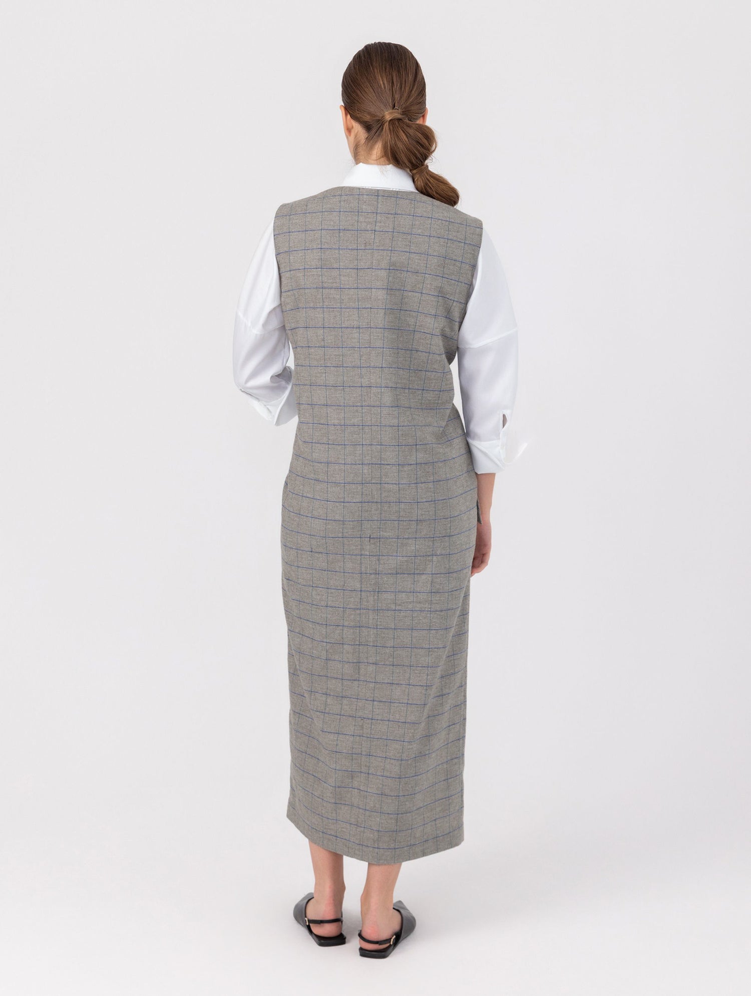 Ärmelloses, locker geschnittenes Kleid mit tiefem V-Ausschnitt und Pattentaschen sowie einem langen Seitenschlitz auf der Vorderseite. Hergestellt aus nachhaltigen Fasern.