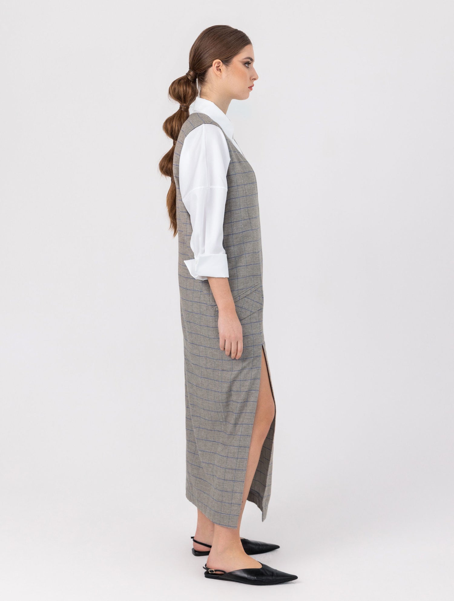 Ärmelloses, locker geschnittenes Kleid mit tiefem V-Ausschnitt und Pattentaschen sowie einem langen Seitenschlitz auf der Vorderseite. Hergestellt aus nachhaltigen Fasern.