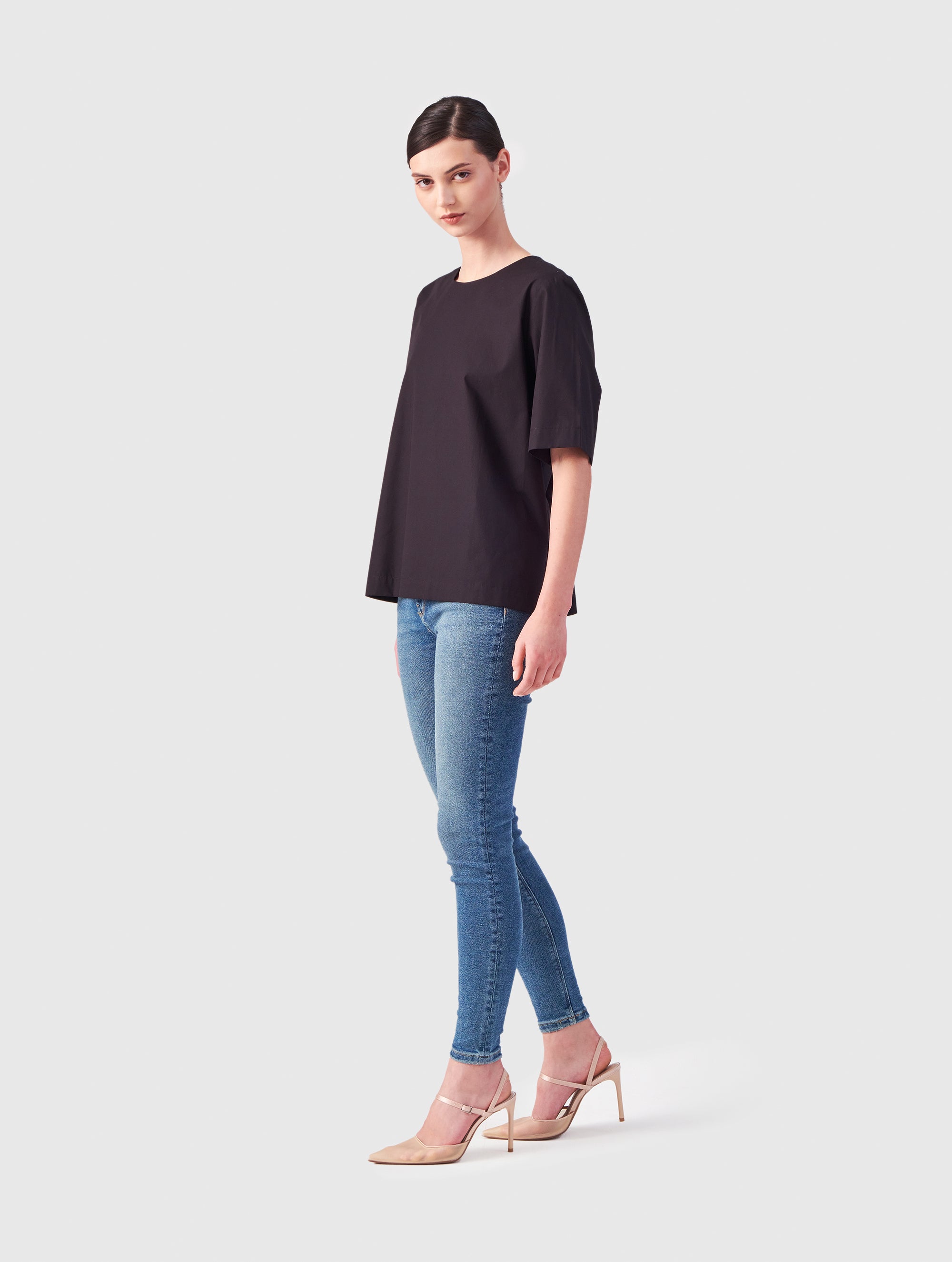 Hochgeschlossene Bluse aus Baumwolle im T-Shirt-Stil mit Knopfverschluss auf der Rückseite.