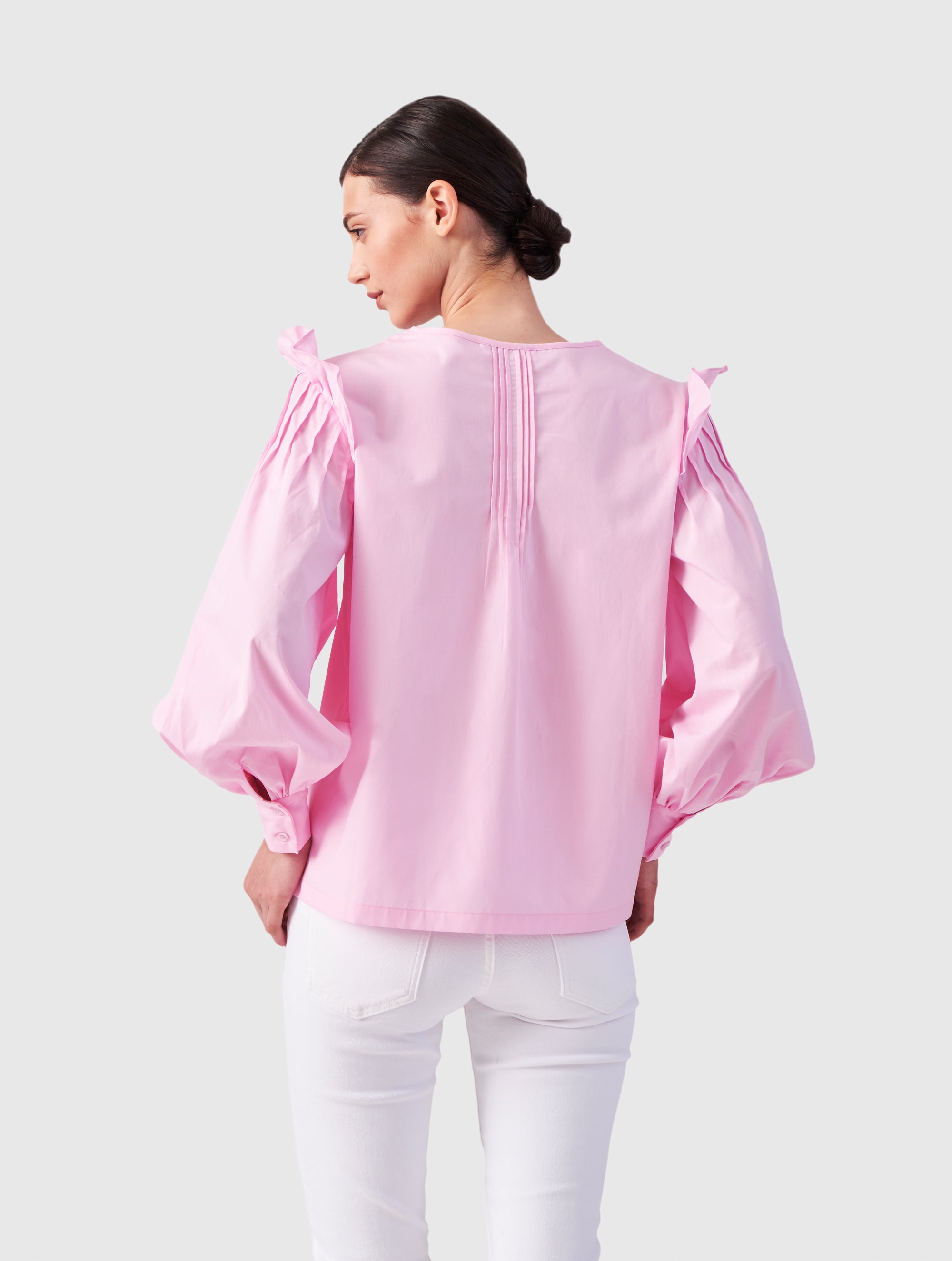 Hochgeschlossene Bluse aus Baumwolle mit weiten Bischofsärmel und Volant-Detail an der Schulternaht, sowie feinen Biesen an der Schulter, wie auch Biesen am Kragen auf der Vorderseite. Aus nachhaltiger Baumwolle gefertigt.