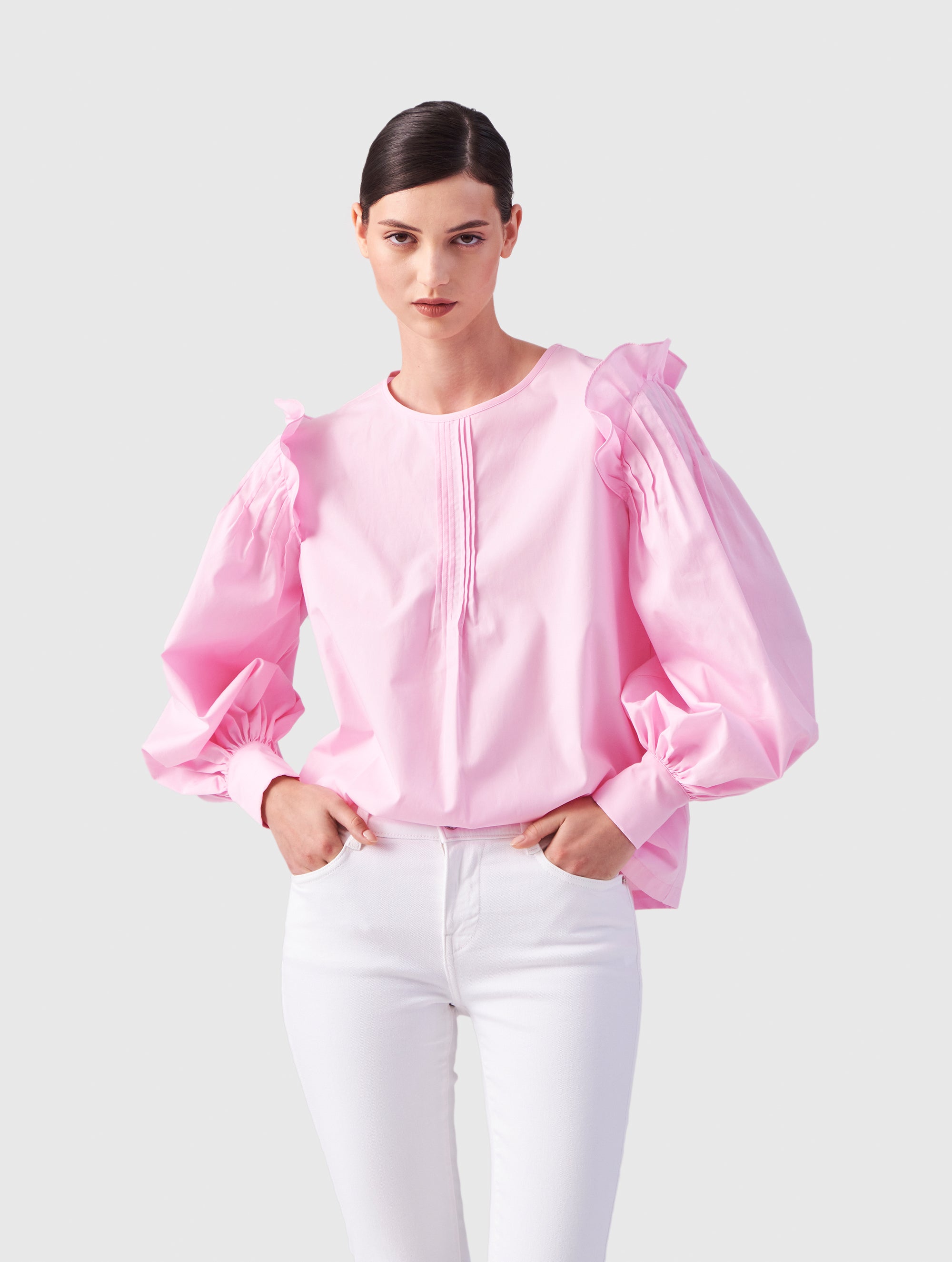 Hochgeschlossene Bluse aus Baumwolle mit weiten Bischofsärmel und Volant-Detail an der Schulternaht, sowie feinen Biesen an der Schulter, wie auch Biesen am Kragen auf der Vorderseite. Aus nachhaltiger Baumwolle gefertigt.
