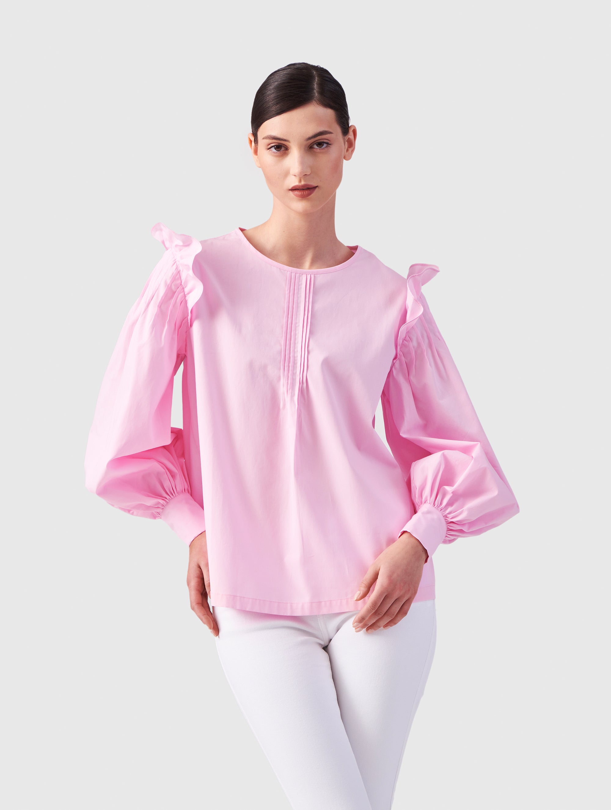 Hochgeschlossene Bluse aus Baumwolle mit weiten Bischofsärmel und Volant-Detail an der Schulternaht, sowie feinen Biesen an der Schulter, wie auch Biesen am Kragen auf der Vorderseite. Aus nachhaltiger Baumwolle gefertigt.