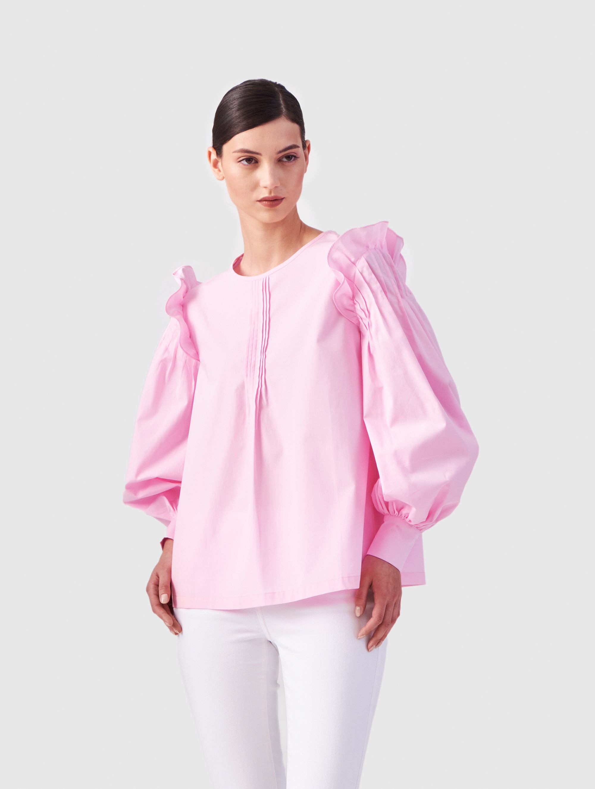 Hochgeschlossene Bluse aus Baumwolle mit weiten Bischofsärmel und Volant-Detail an der Schulternaht, sowie feinen Biesen an der Schulter, wie auch Biesen am Kragen auf der Vorderseite. Aus nachhaltiger Baumwolle gefertigt.
