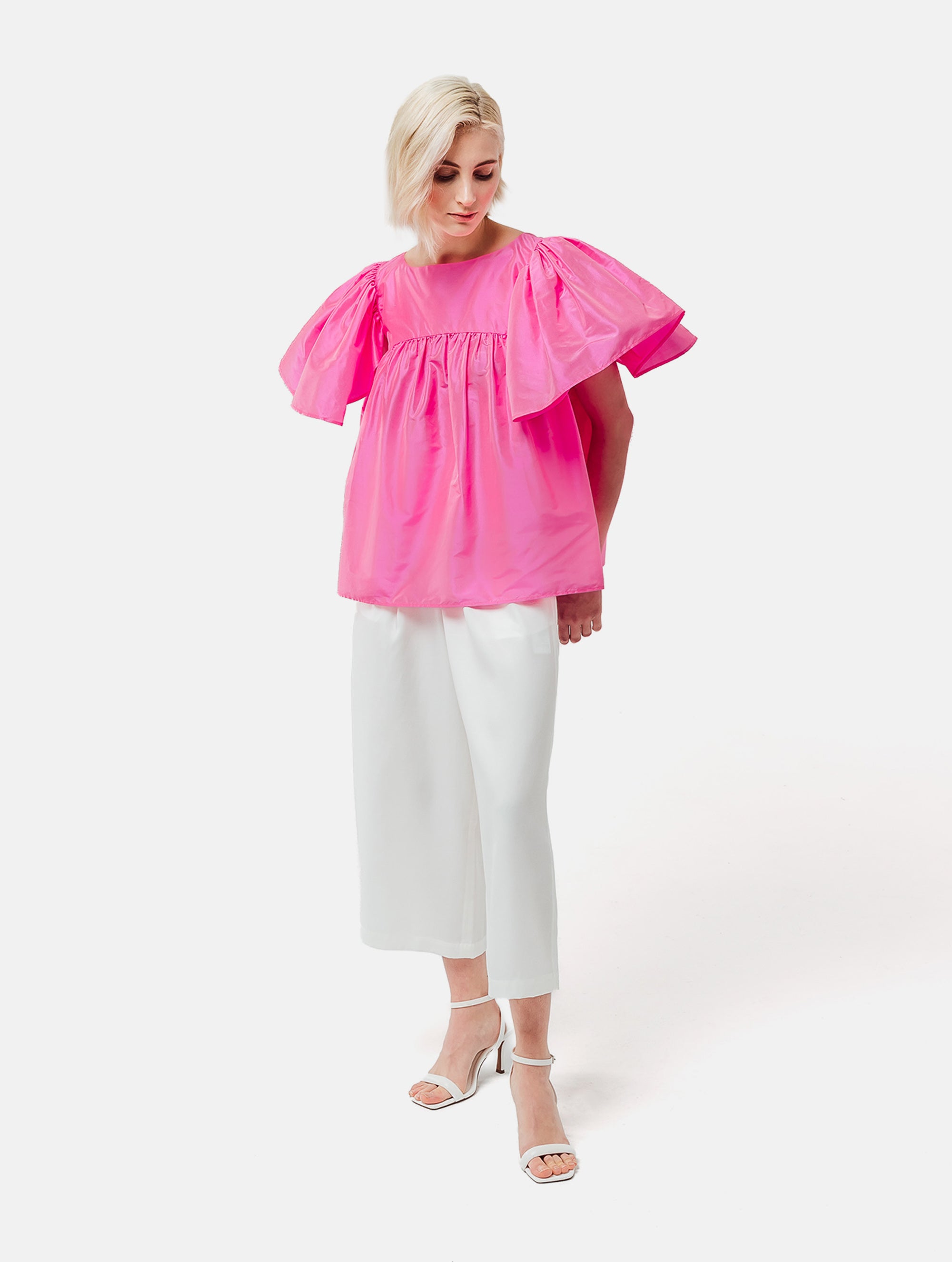 Weit geschnittene Bluse mit breitem Volantärmel und raffiniertem Rückenausschnitt aus pinken Dupionsilk, sowie versteckten Taschen in der Seitennaht. Zusätzlich mit breiten Gürtel zum Binden tragbar. Dieses Produkt ist Teil unserer Reborn Linie.