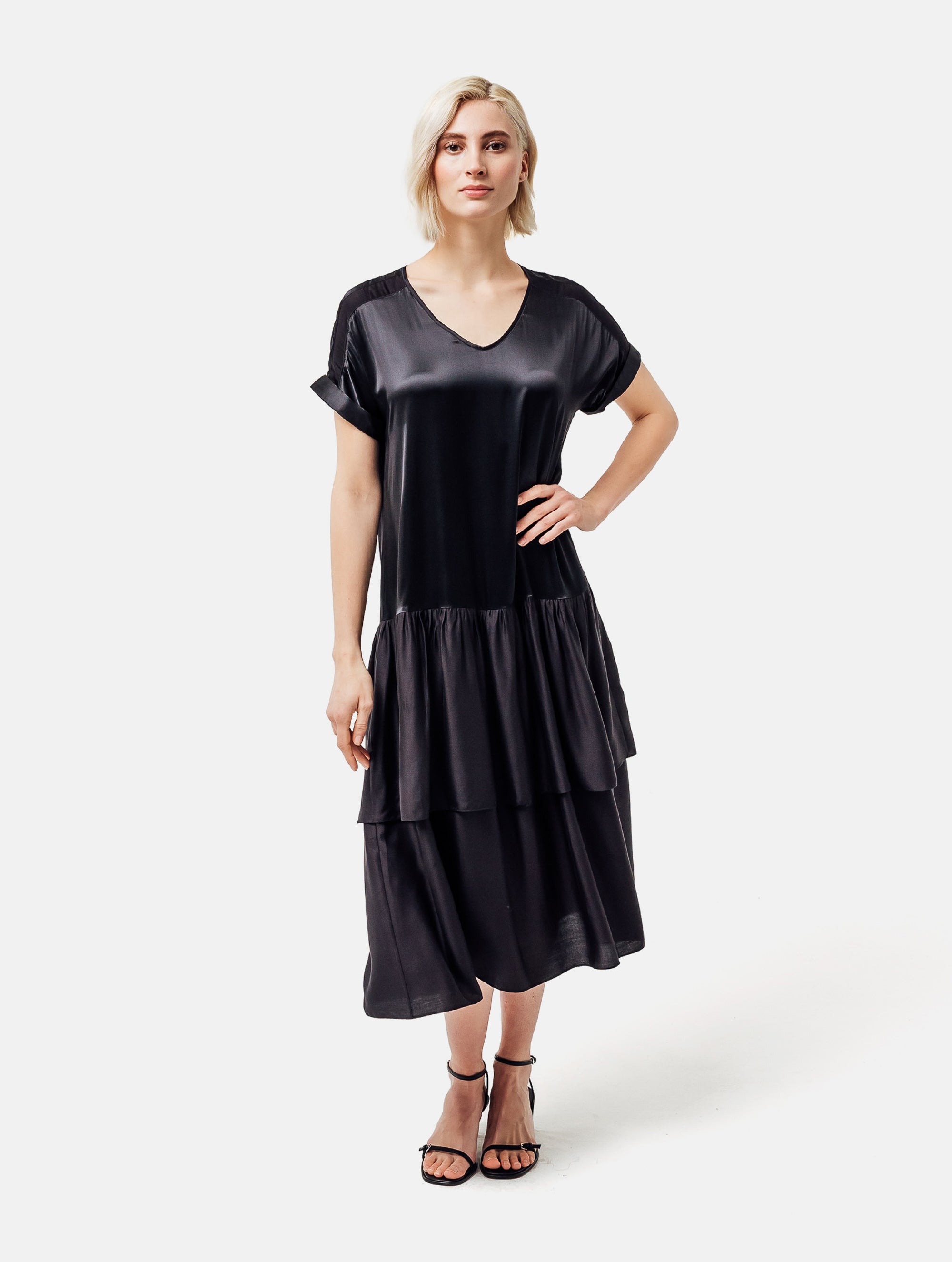 Locker fallendes Kurzarmkleid mit V-Ausschnitt und Volantrock aus Seidensatin und Viskose. Dieses Produkt ist Teil unserer Reborn Linie.
