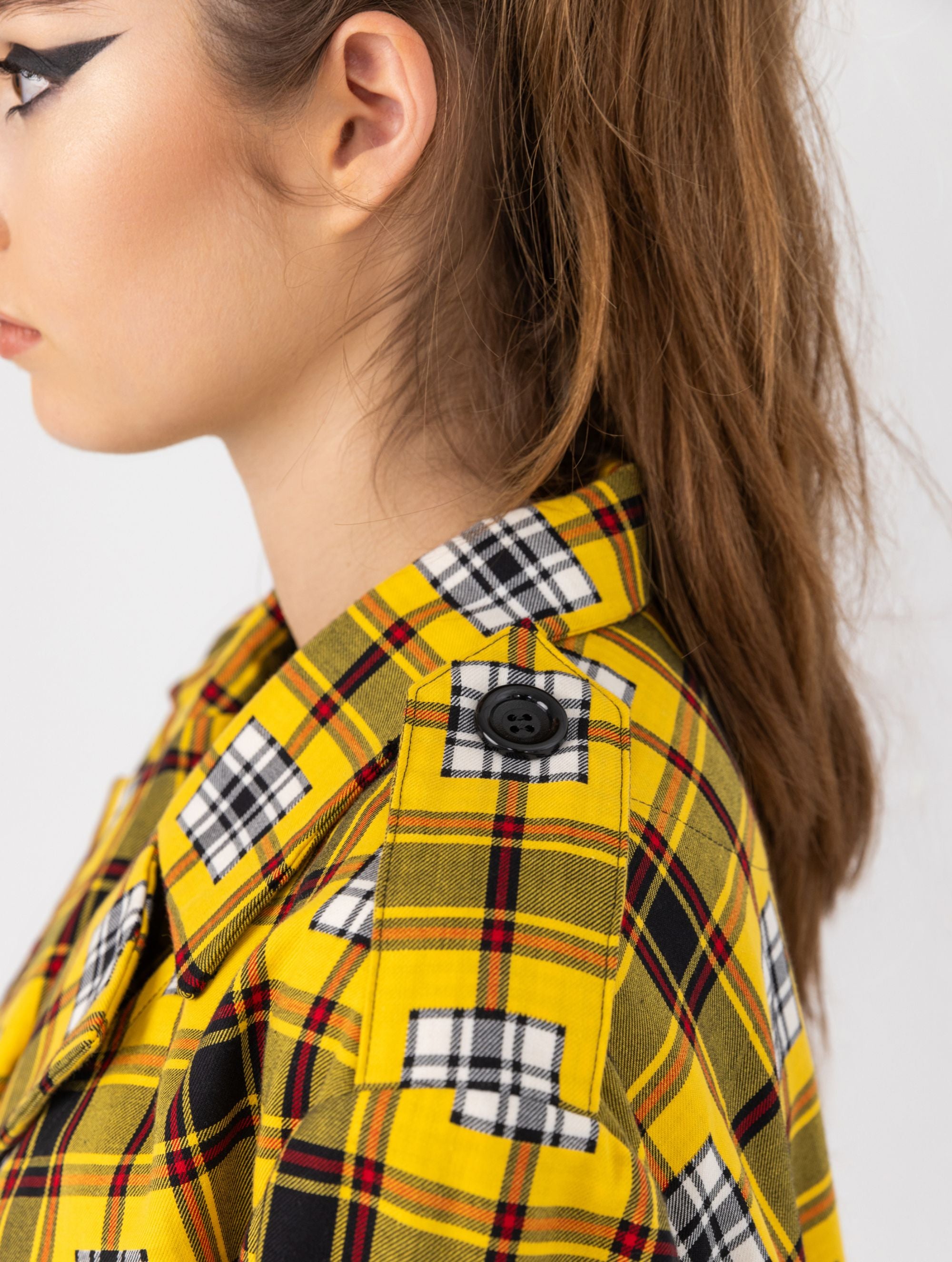 Doppelseitige Karo-Kurzjacke mit abnehmbaren Schulterpolstern, eingesetzten Ärmeln mit Ärmelgürteln und Schulterklappen sowie vorderen Halbpasse. Die Jacke kann von beiden Seiten getragen werden. Hergestellt aus Naturfasern.