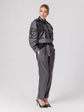 Grade geschnittene Kurzjacke mit Einsätzen, aufgesetzten Taschen, Schulterklappen und anderen Details aus veganem Leder, ausgestattet mit Druckknöpfen. Dieses Modell ist Teil unserer REBORN-Kollektion und steht für unsere "Zero-Waste-Politik".