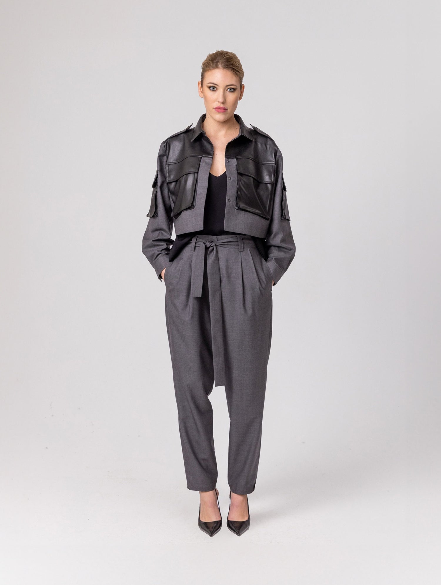 Grade geschnittene Kurzjacke mit Einsätzen, aufgesetzten Taschen, Schulterklappen und anderen Details aus veganem Leder, ausgestattet mit Druckknöpfen. Dieses Modell ist Teil unserer REBORN-Kollektion und steht für unsere "Zero-Waste-Politik".