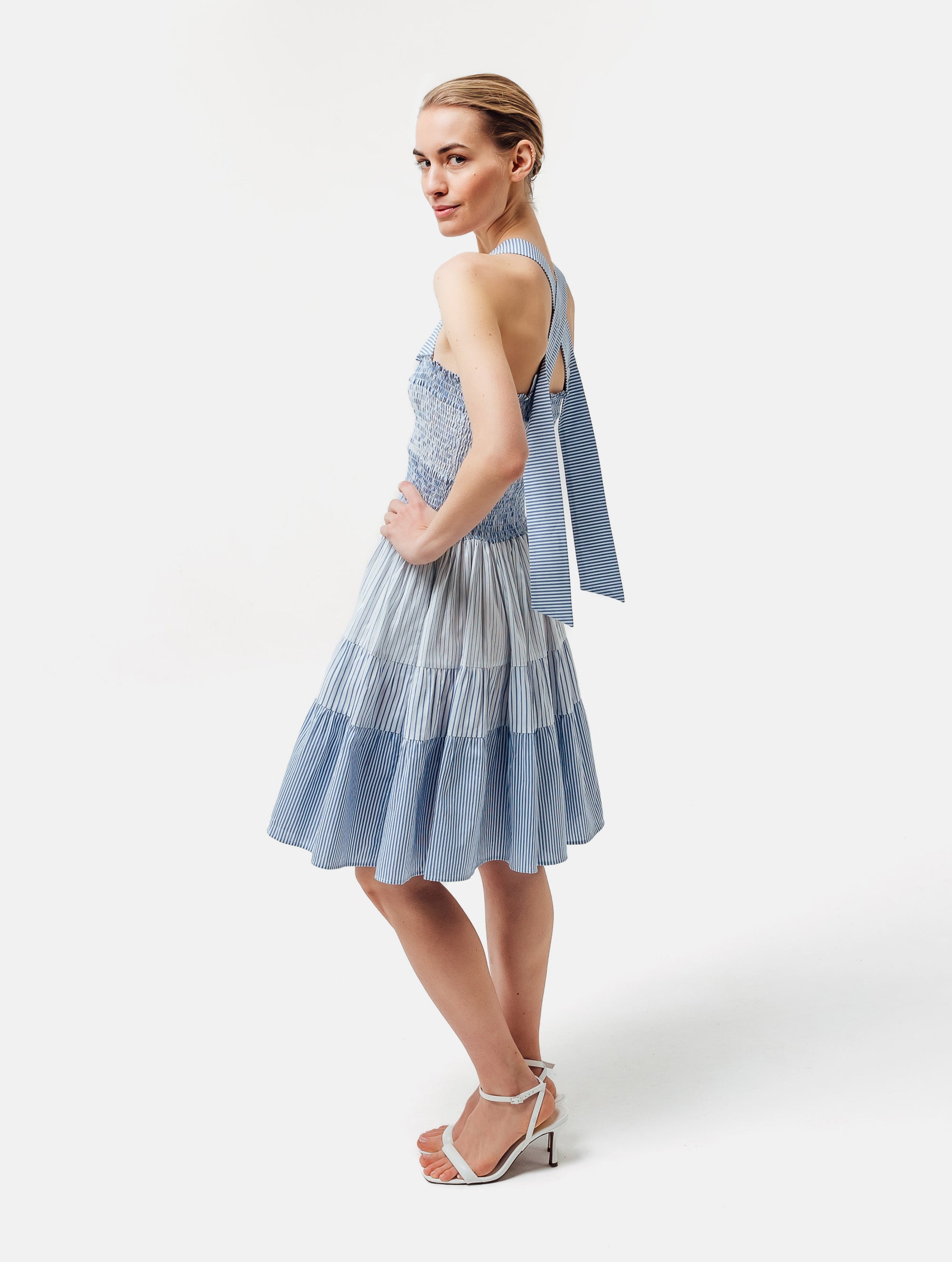 Ausgestelltes Midikleid, unterschiedlichen Stoffkomponenten mit elastischen Smocking im Oberteil, die breiten Träger können auf zwei unterschiedliche Weisen getragen werden, parallel oder überkreuzt durch 2 Köpfe auf der Rückseite. Reborn, da aus Katarina gemacht.