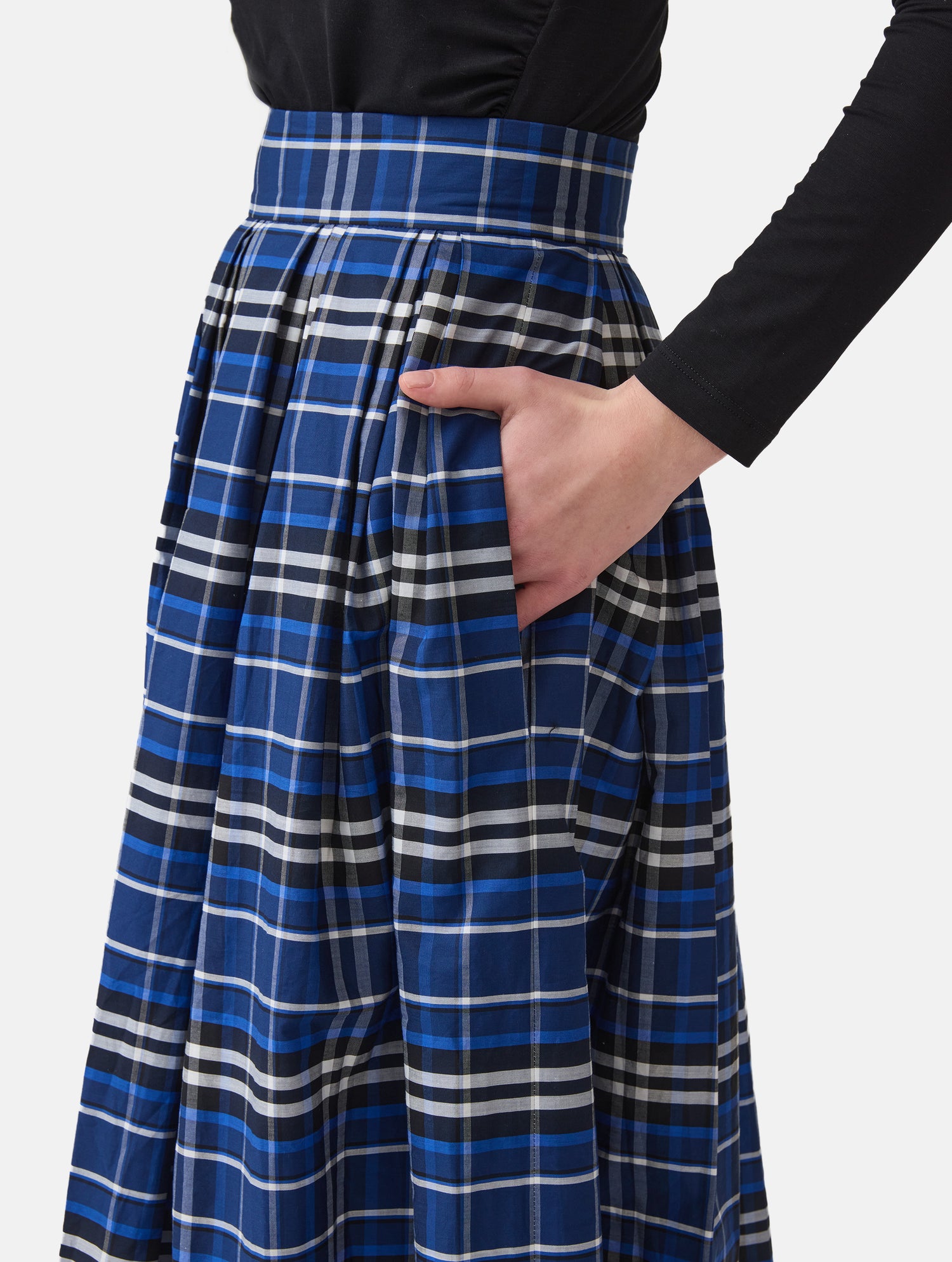 Weit ausgestellter Midirock aus karierter Baumwolle mit in Falten gelegtem und tailliertem Rockbund, versteckten Taschen in der Seitennaht, sowie einem Reißverschluß auf der Rückseite. Dieses Modell ist Teil unserer REBORN-Linie und steht für unsere "Zero-Waste-Politik", da mit Stoff aus einem Deadstock stammt.