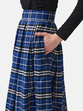Weit ausgestellter Midirock aus karierter Baumwolle mit in Falten gelegtem und tailliertem Rockbund, versteckten Taschen in der Seitennaht, sowie einem Reißverschluß auf der Rückseite. Dieses Modell ist Teil unserer REBORN-Linie und steht für unsere "Zero-Waste-Politik", da mit Stoff aus einem Deadstock stammt.