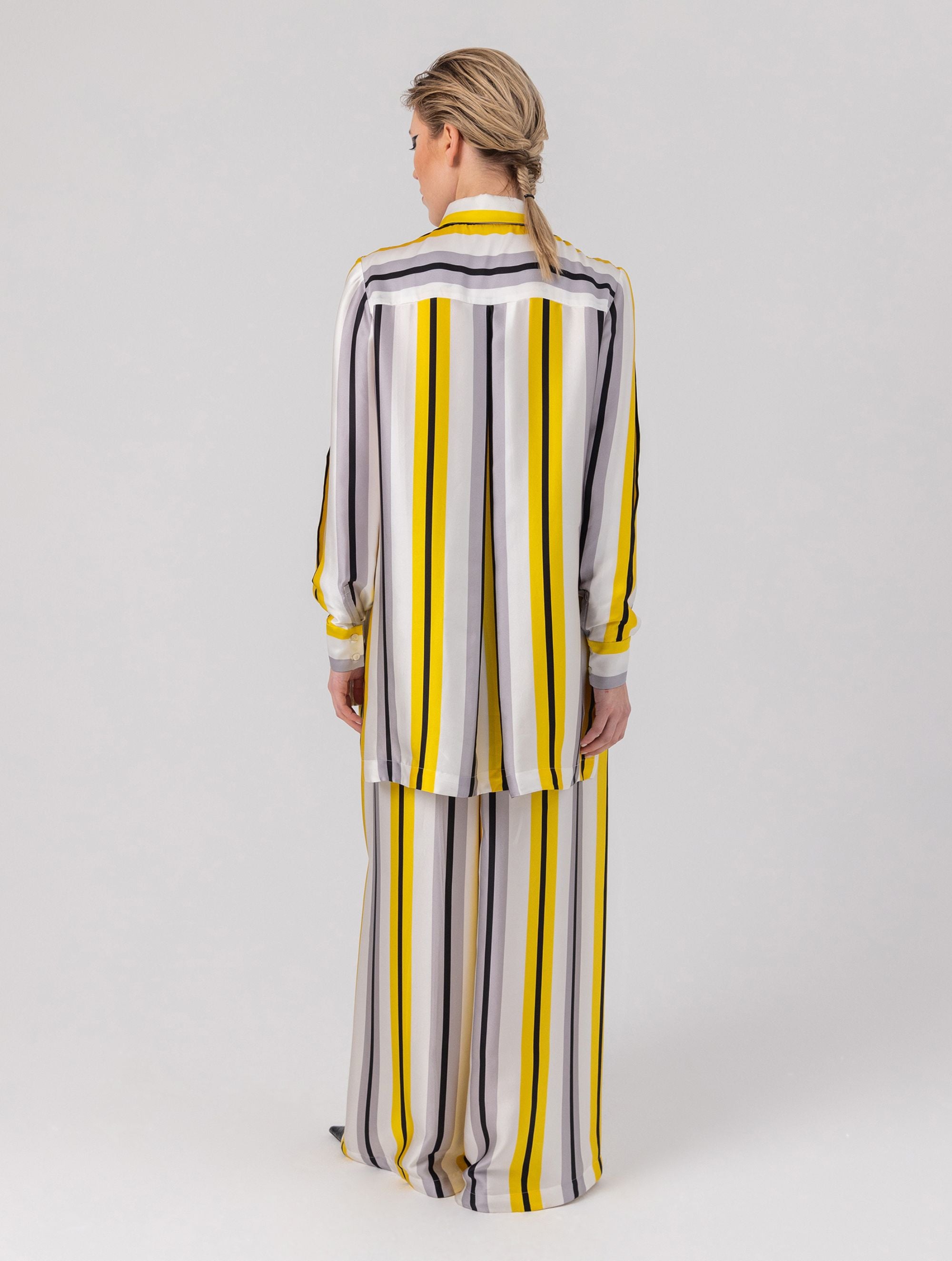 Bedruckte Oversize-Seidenbluse aus Satin mit Hemdkragen, aufgesetzten Taschen auf der Vorderseite und Kellerfalte auf der Rückseite sowie schwarzem Chiffonschal. Hergestellt aus Naturfasern, sowie Stoffen aus unserem Altbestand im Sinne unserer "Zero-Waste-Politik".