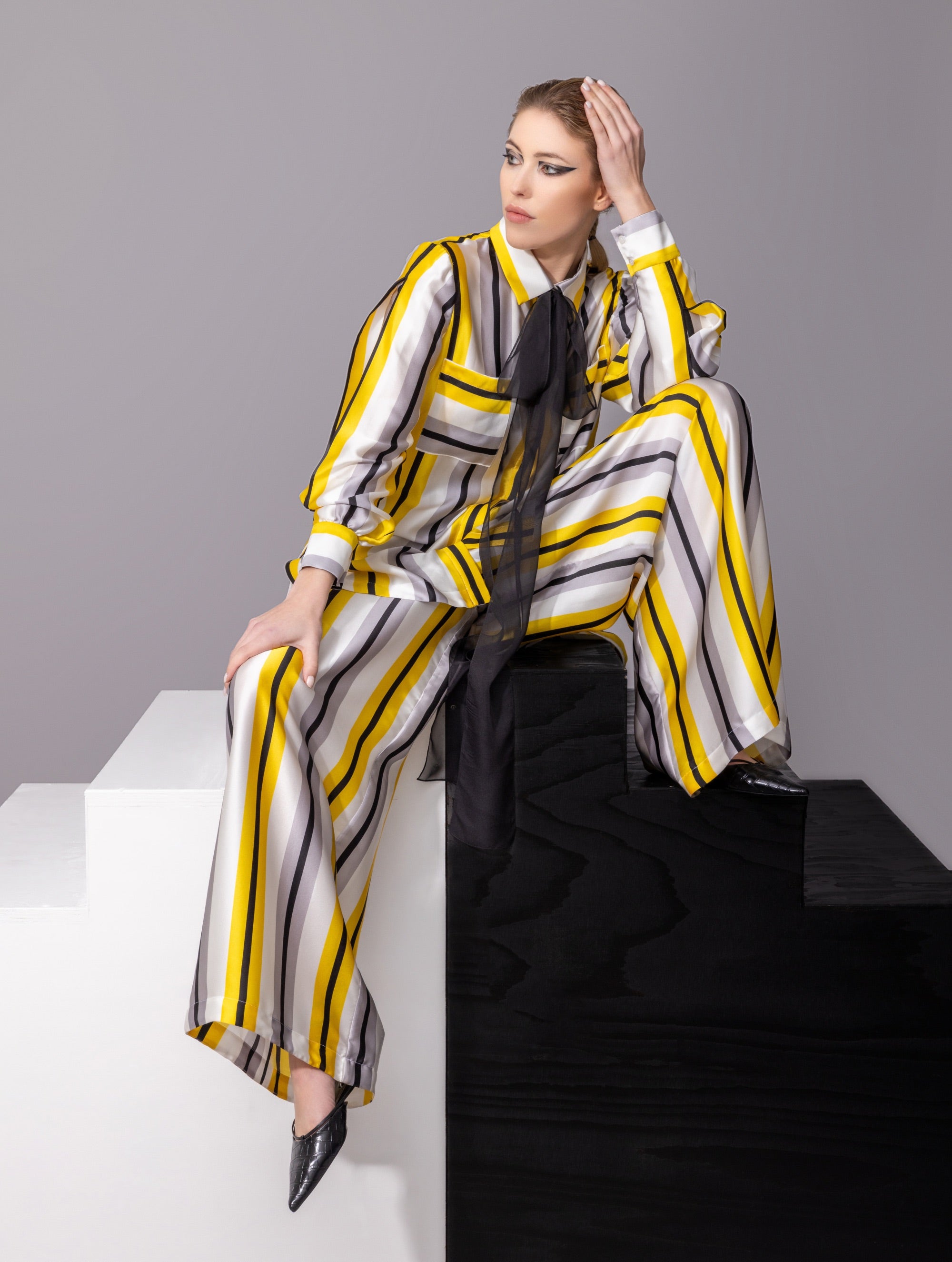 Bedruckte Oversize-Seidenbluse aus Satin mit Hemdkragen, aufgesetzten Taschen auf der Vorderseite und Kellerfalte auf der Rückseite sowie schwarzem Chiffonschal. Hergestellt aus Naturfasern, sowie Stoffen aus unserem Altbestand im Sinne unserer "Zero-Waste-Politik".
