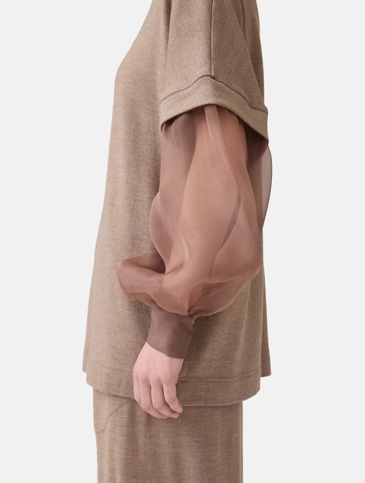 Locker geschnittener Rundauschnitt Pullover mit angesetzten weiten Bischofsärmeln aus feinem Organza mit Hemdmanschetten und Knöpfen. Dieses Modell ist Teil unserer REBORN-Linie und steht für unsere "Zero-Waste-Politik", da mit Stoff aus Altbestand gefertigt.