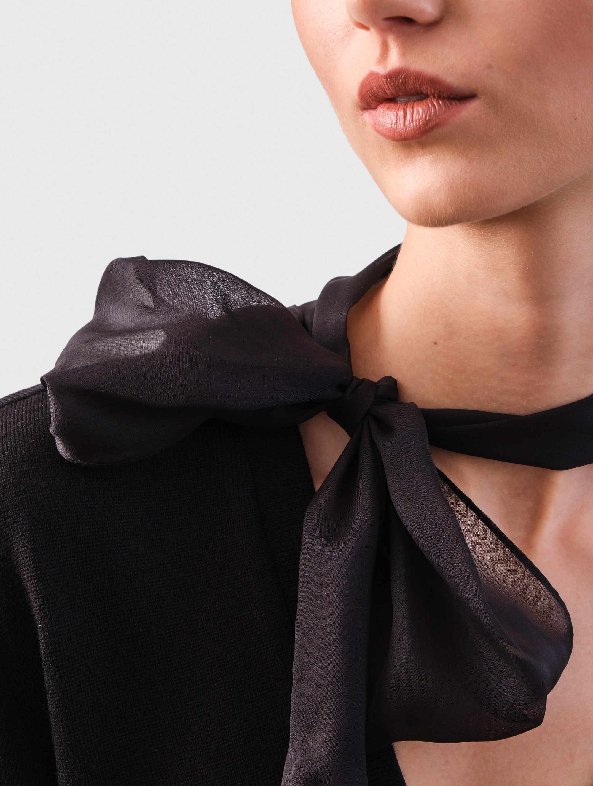 Locker geschnittener V-Ausschnitt-Pullover mit integriertem langen und schmalen Chiffon-Seidenschal. Dieses Modell ist Teil unserer REBORN-Kollektion und steht für unsere "Zero-Waste-Politik".