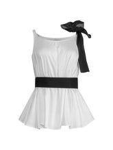 Weit geschnittenes Tanktop aus weißer Baumwolle mit schwarzem Schleifendetail und seperaten Gürtel aus schwarzer Baumwolle. Versteckte Seitentaschen in den Seitennähten. Dieses Produkt ist Teil unserer Reborn Linie.