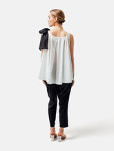 Weit geschnittenes Tanktop aus weißer Baumwolle mit schwarzem Schleifendetail und seperaten Gürtel aus schwarzer Baumwolle. Versteckte Seitentaschen in den Seitennähten. Dieses Produkt ist Teil unserer Reborn Linie.