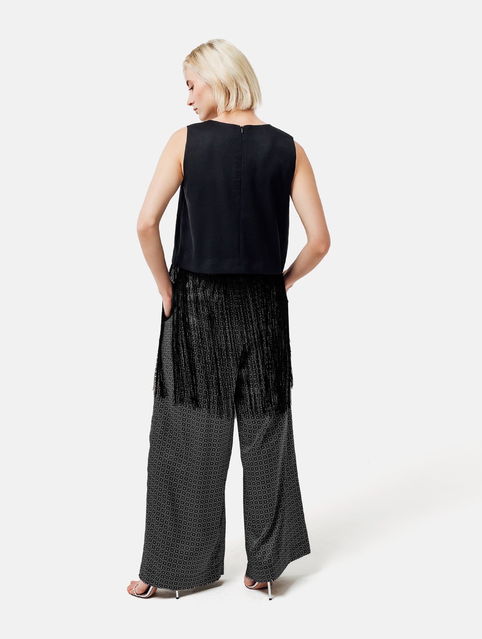 Grade geschnittenes kurzes Top aus Woll-Mix mit abnehmbaren langen Fransen aus Viskose. Dieses Modell ist Teil unserer Reborn Linie, da aus dem ehemaligen Top Alissa hergestellt worden ist.