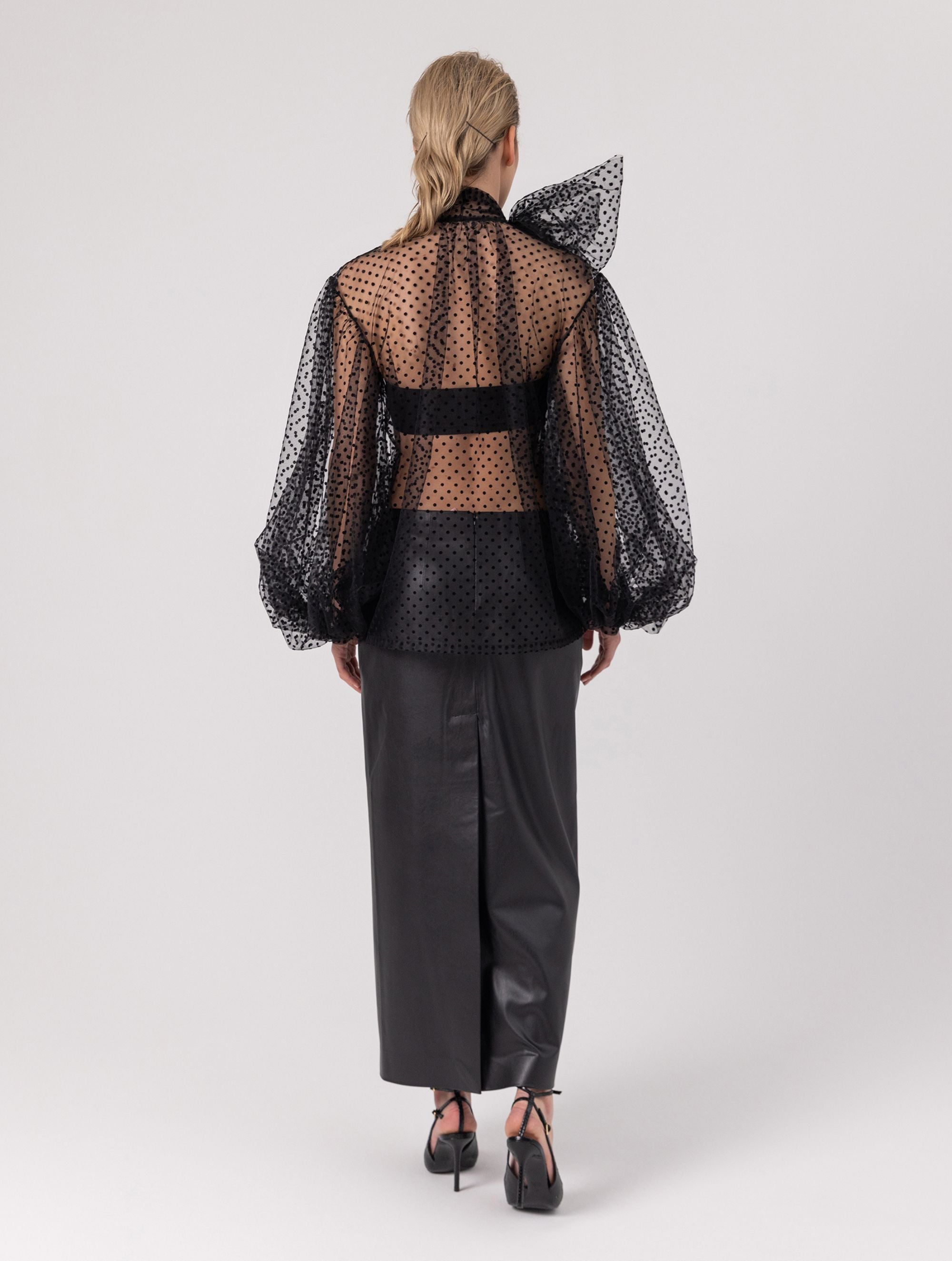 Extravagante gepunktete Tüllbluse mit tiefem V-Ausschnitt, weiten Dichterärmeln und extra langem Schalkragen. Dieses Modell ist Teil unserer REBORN-Kollektion und steht für unsere "Zero-Waste-Politik".