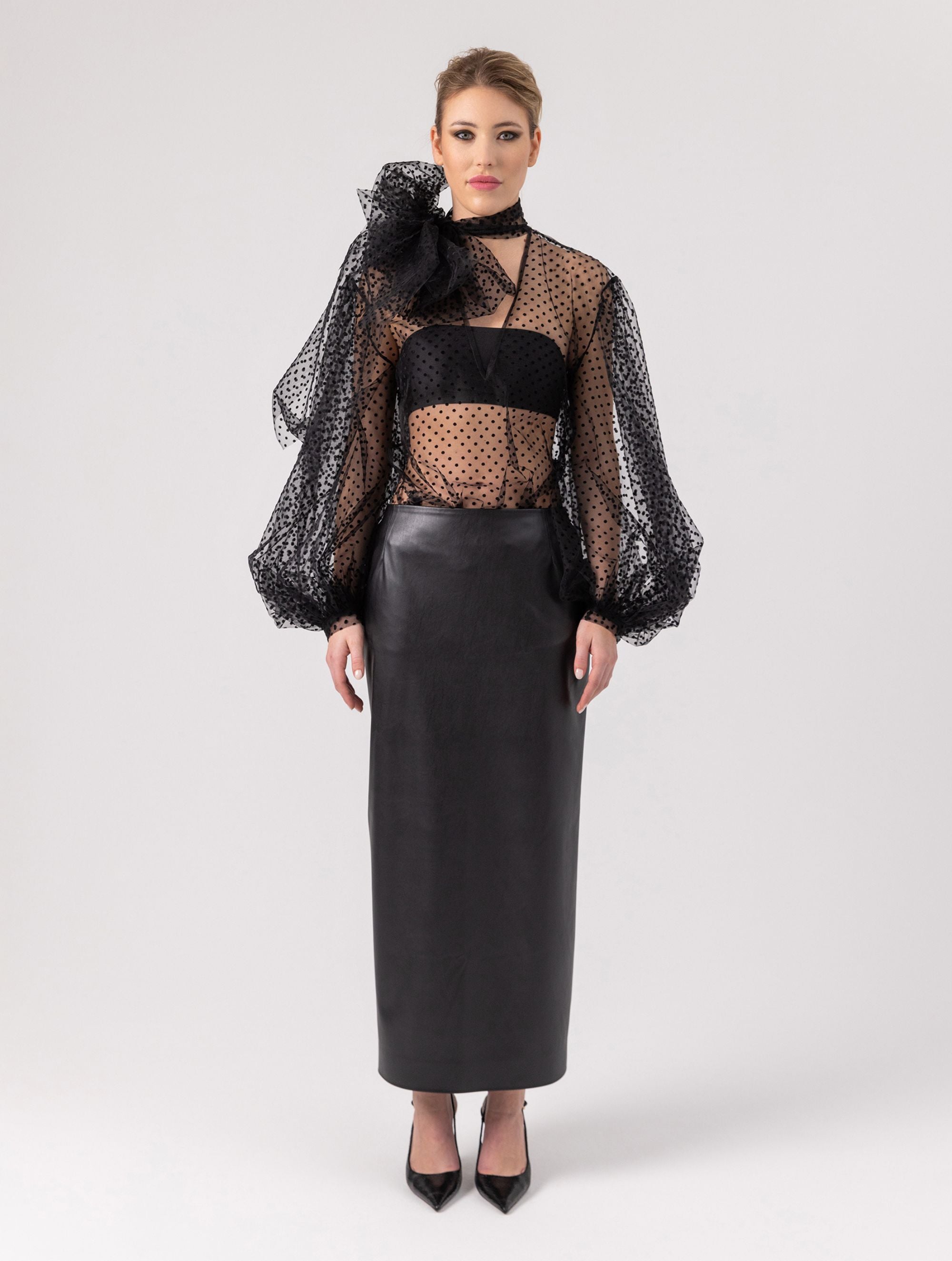 Extravagante gepunktete Tüllbluse mit tiefem V-Ausschnitt, weiten Dichterärmeln und extra langem Schalkragen. Dieses Modell ist Teil unserer REBORN-Kollektion und steht für unsere "Zero-Waste-Politik".