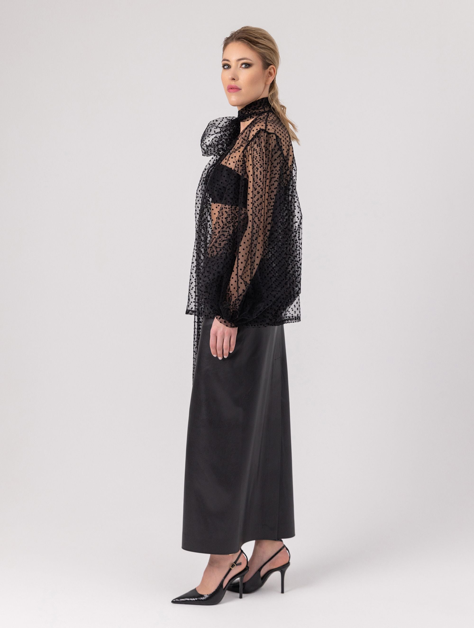 Extravagante gepunktete Tüllbluse mit tiefem V-Ausschnitt, weiten Dichterärmeln und extra langem Schalkragen. Dieses Modell ist Teil unserer REBORN-Kollektion und steht für unsere "Zero-Waste-Politik".