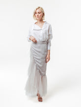 Figurbetonter knielanger Wickelrock mit doppelgelegtem breiten Volant aus Tüll und Bändern zum Binden in der Taille. Dieses Modell ist Teil unserer Reborn Linie, da es aus dem ehemaligen Rock Berta hergestellt worden ist.