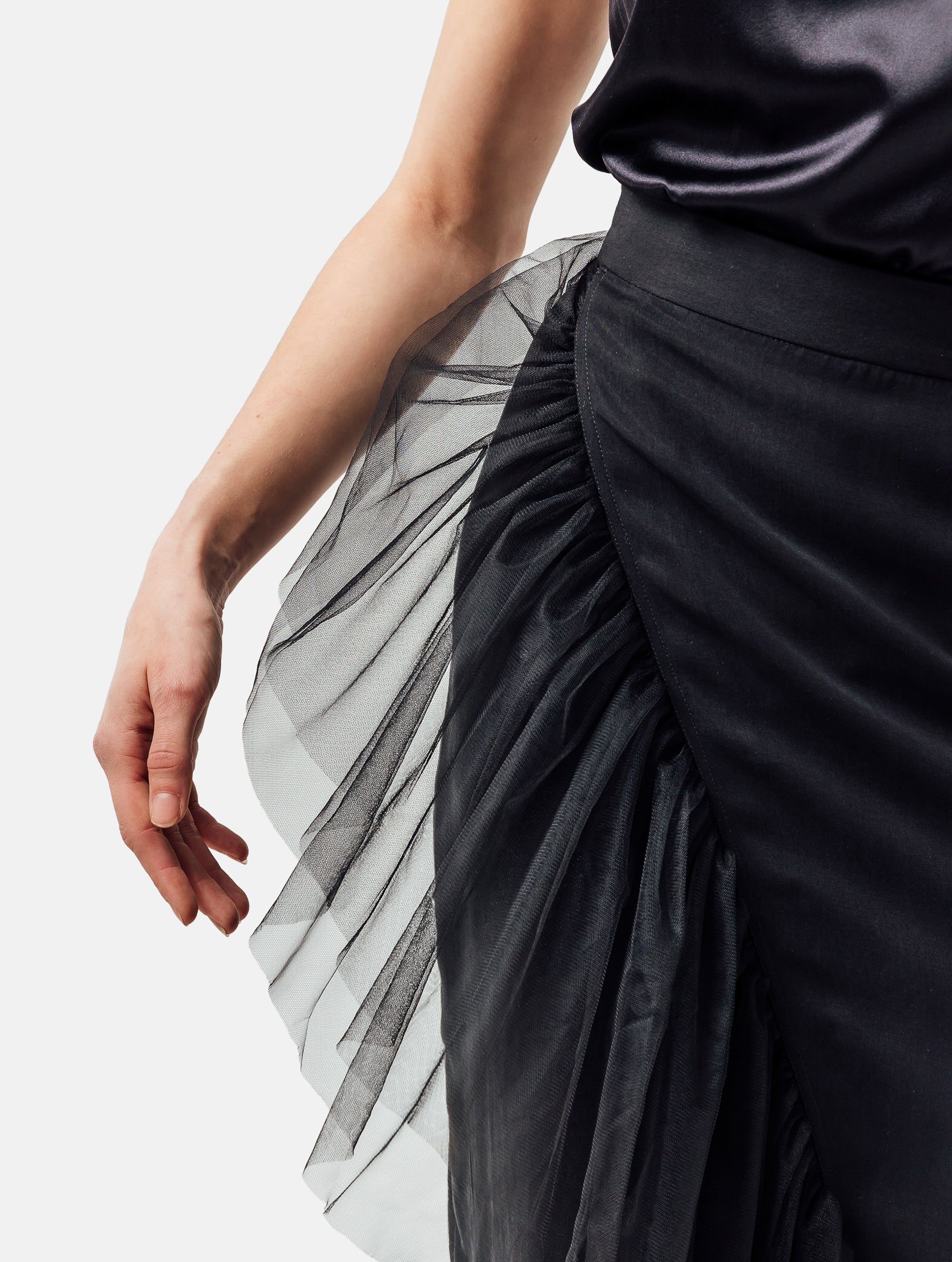 Figurbetonter knielanger Wickelrock mit doppelgelegtem breiten Volant aus Tüll und Bändern zum Binden in der Taille. Dieses Modell ist Teil unserer Reborn Linie, da es aus dem ehemaligen Rock Berta hergestellt worden ist.