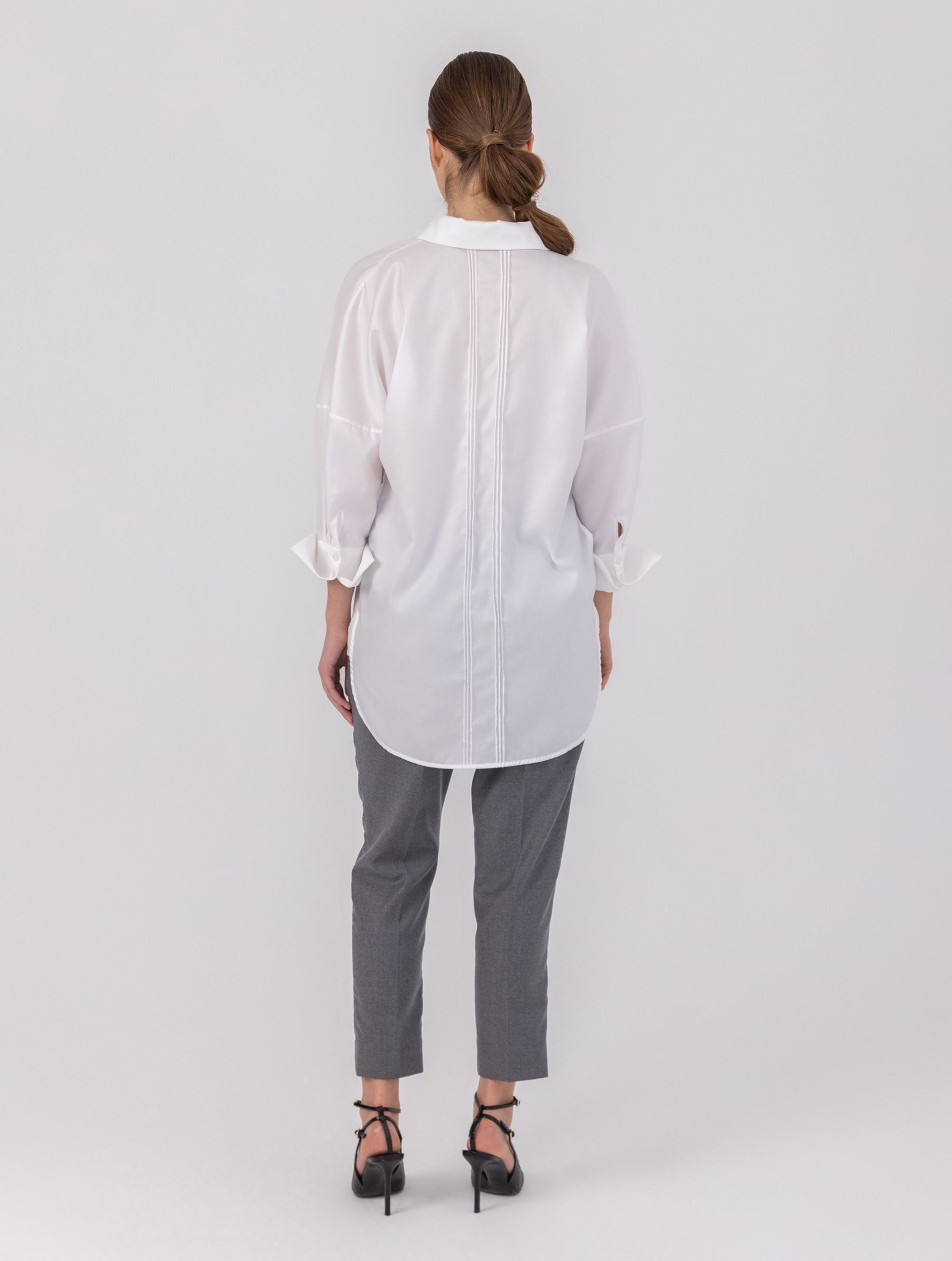 Oversize-Bluse mit Kent-Kragen, breiten Manschetten und Biesen-Details auf der Vorder- und Rückseite. Dieses Modell ist Teil unserer REBORN-Kollektion und steht für unsere „Zero-Waste-Politik“.