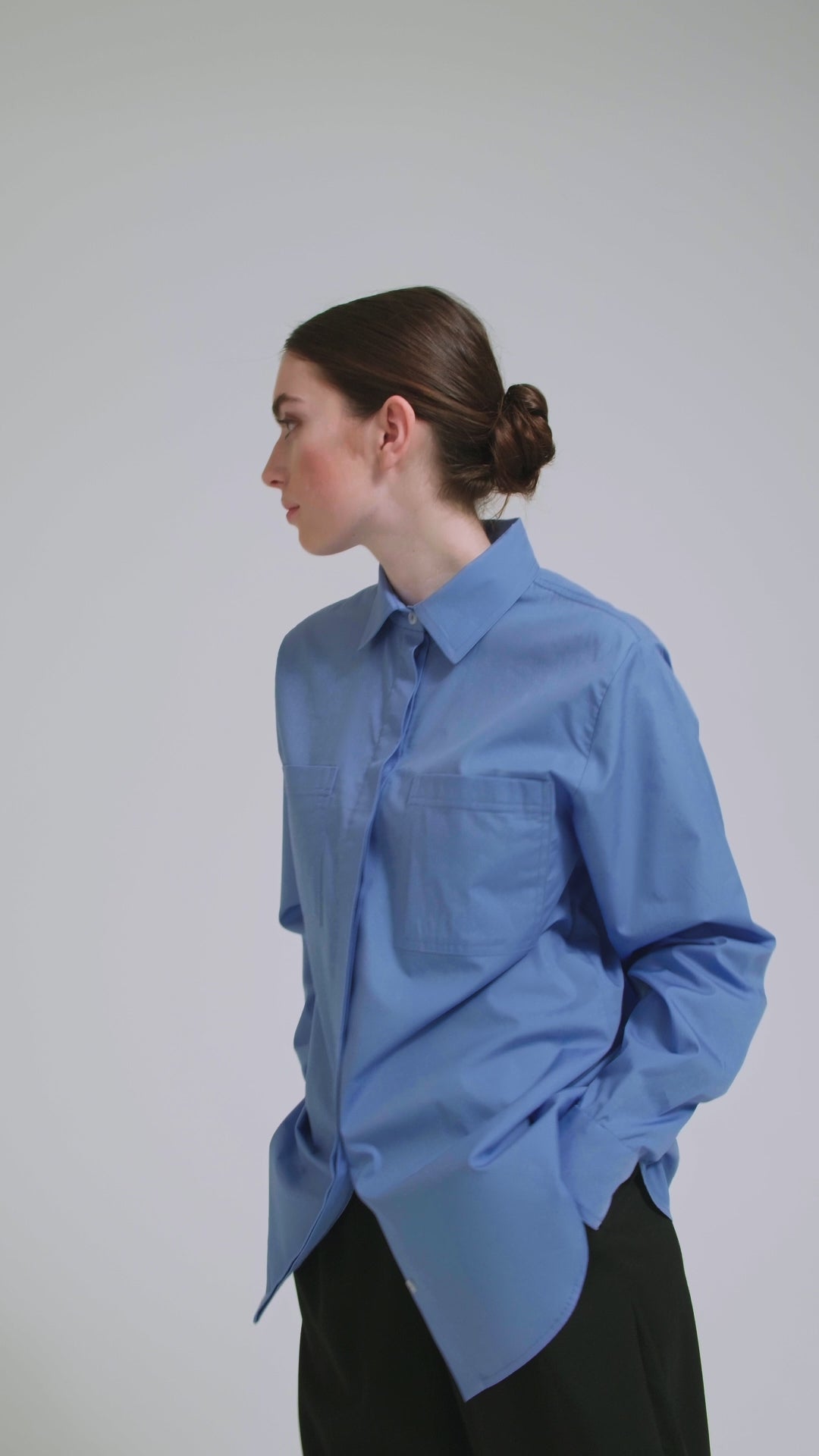 Langes Oversize Blusenhemd mit klassischem Hemdkragen und Manschetten, sowie zwei aufgesetzten Brutstaschen und abgerundeten Saumende im Rückteil. Dieses Modell ist Teil unserer REBORN-Linie und steht für unsere "Zero-Waste-Politik", da mit Stoff aus Altbestand gefertigt.