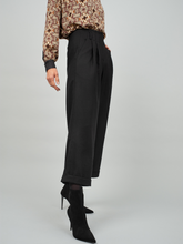 Schwarze Woll-Culotte mit hohem Bund Bundfalten, seitlichen Taschen und kleinen Aufschlägen am Hosenbein