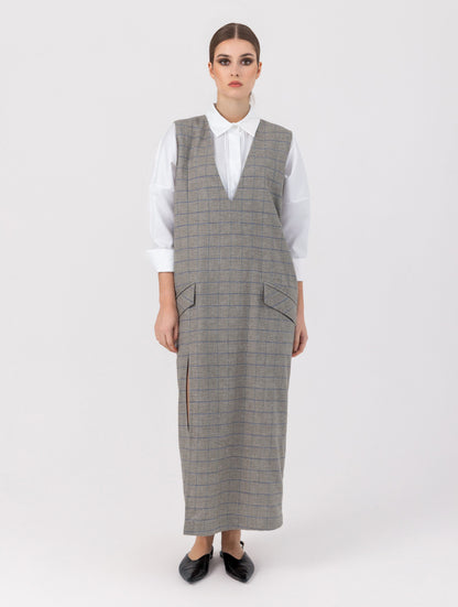 Ärmelloses, locker geschnittenes Kleid mit tiefem V-Ausschnitt und Pattentaschen sowie einem langen Seitenschlitz auf der Vorderseite. Hergestellt aus nachhaltigen Fasern.