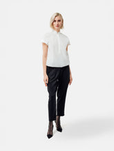 Bluse aus 100% feiner Baumwolle, kleinem Stehkragen, verkürzter Knopfleiste und einem elastischem Bund am Saumende.