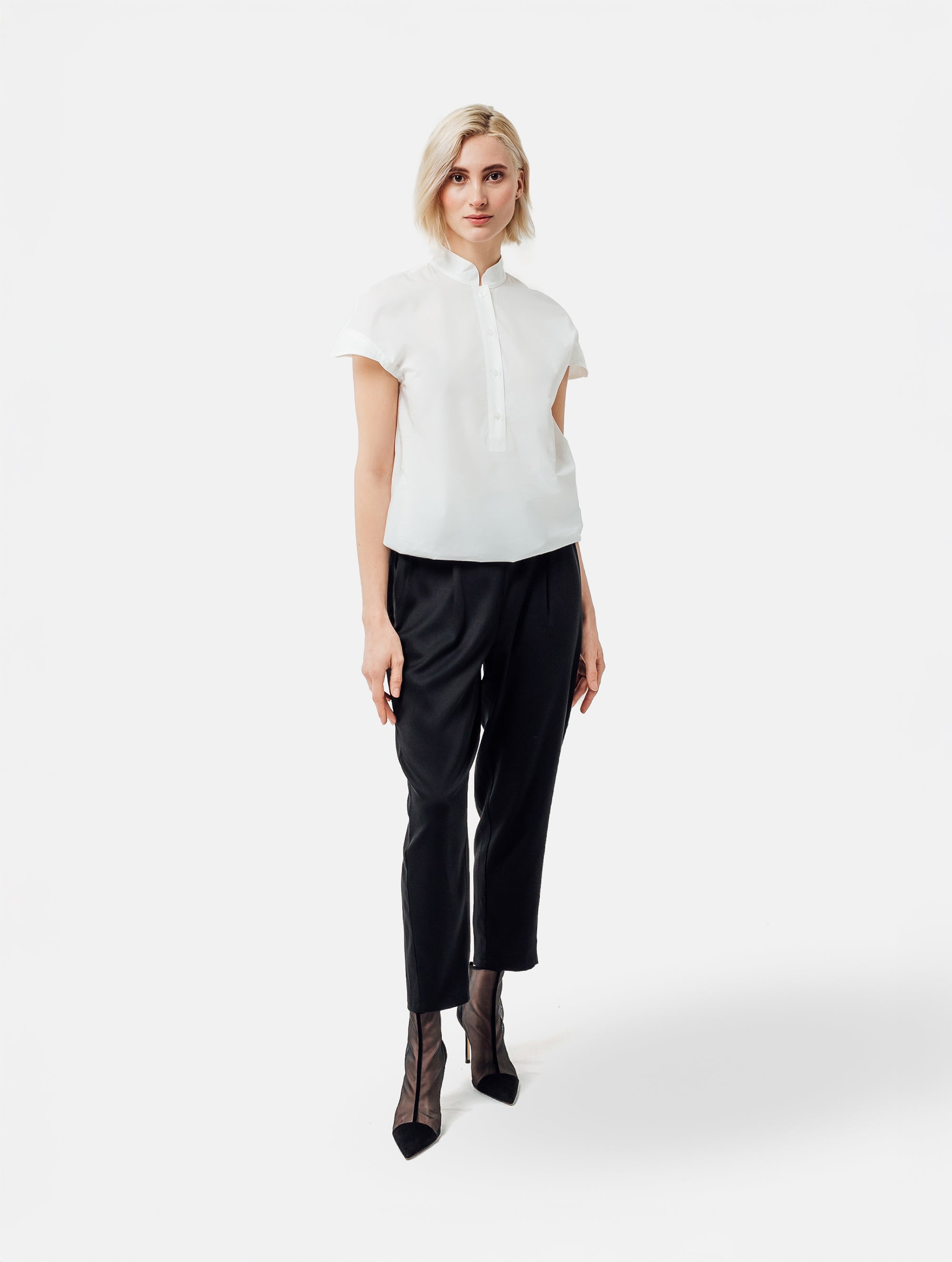 Bluse aus 100% feiner Baumwolle, kleinem Stehkragen, verkürzter Knopfleiste und einem elastischem Bund am Saumende.
