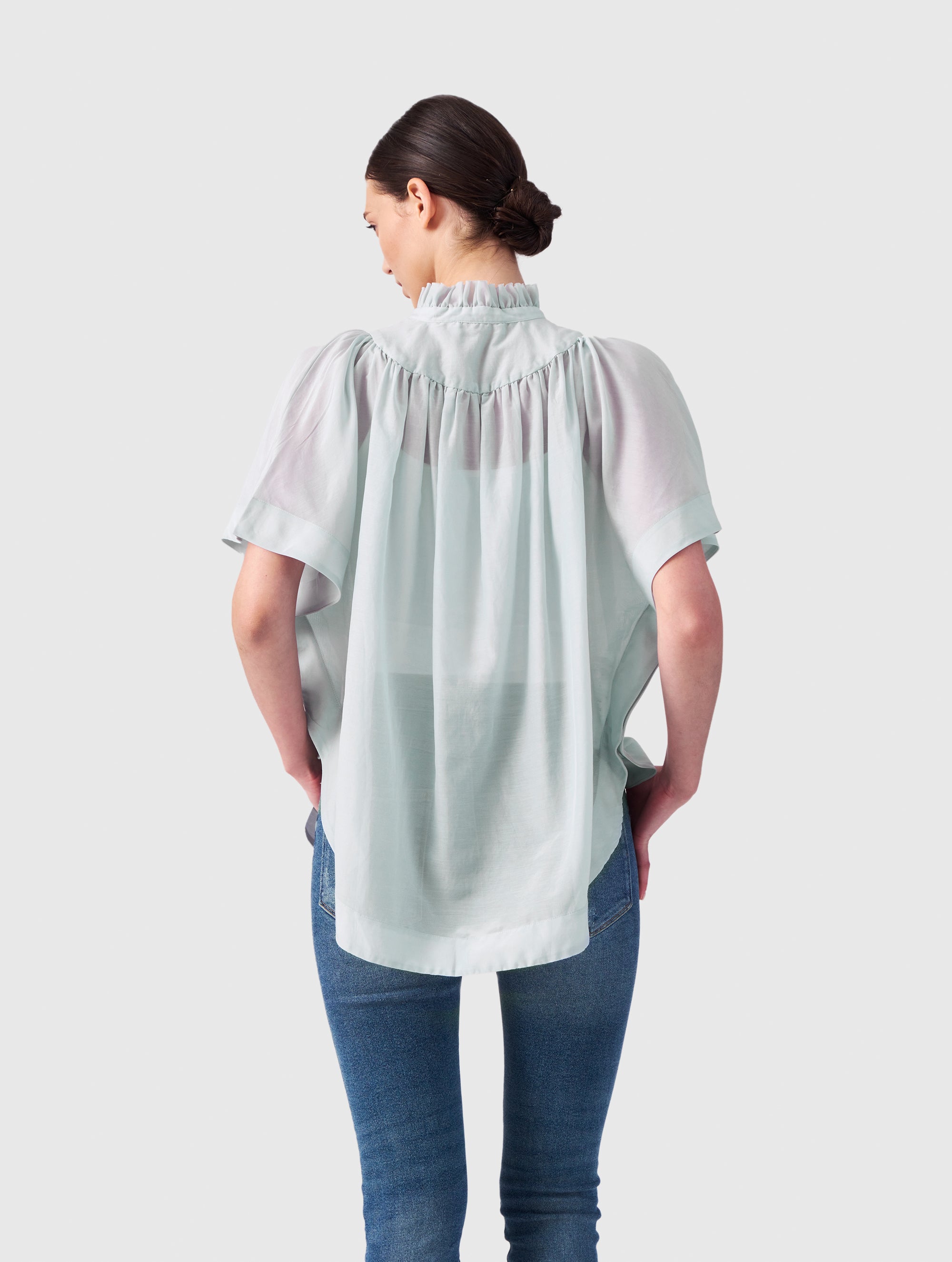 Transparente Bluse mit Stehkragen, auffälligen Ärmeln und durchgehender Knopfleiste auf der Vorderseite. Gefertigt aus einer hochwertigen Baumwoll-Seiden-Mischung.