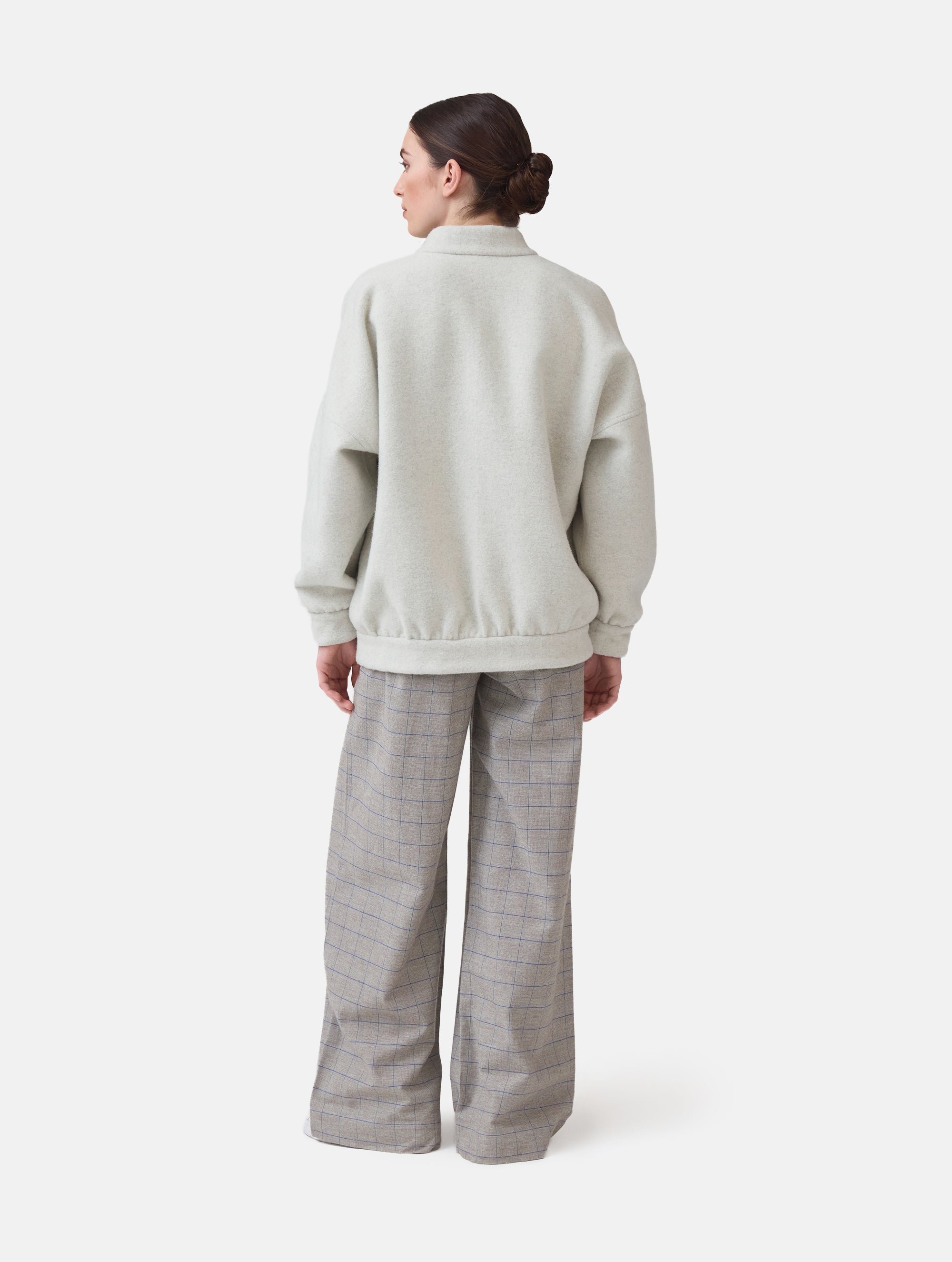 Wendbare Blousonjacke aus hochwertiger Merinowolle mit Stehkragen, Bündchen an den Ärmelenden und am Saumende, sowie seitlichen Leistentaschen auf der helleren Seite und großen aufgesetzten Taschen auf der dunkleren Seite. Dieses Modell ist Teil unserer REBORN-Linie und steht für unsere "Zero-Waste-Politik", da mit Stoff aus Altbestand gefertigt.