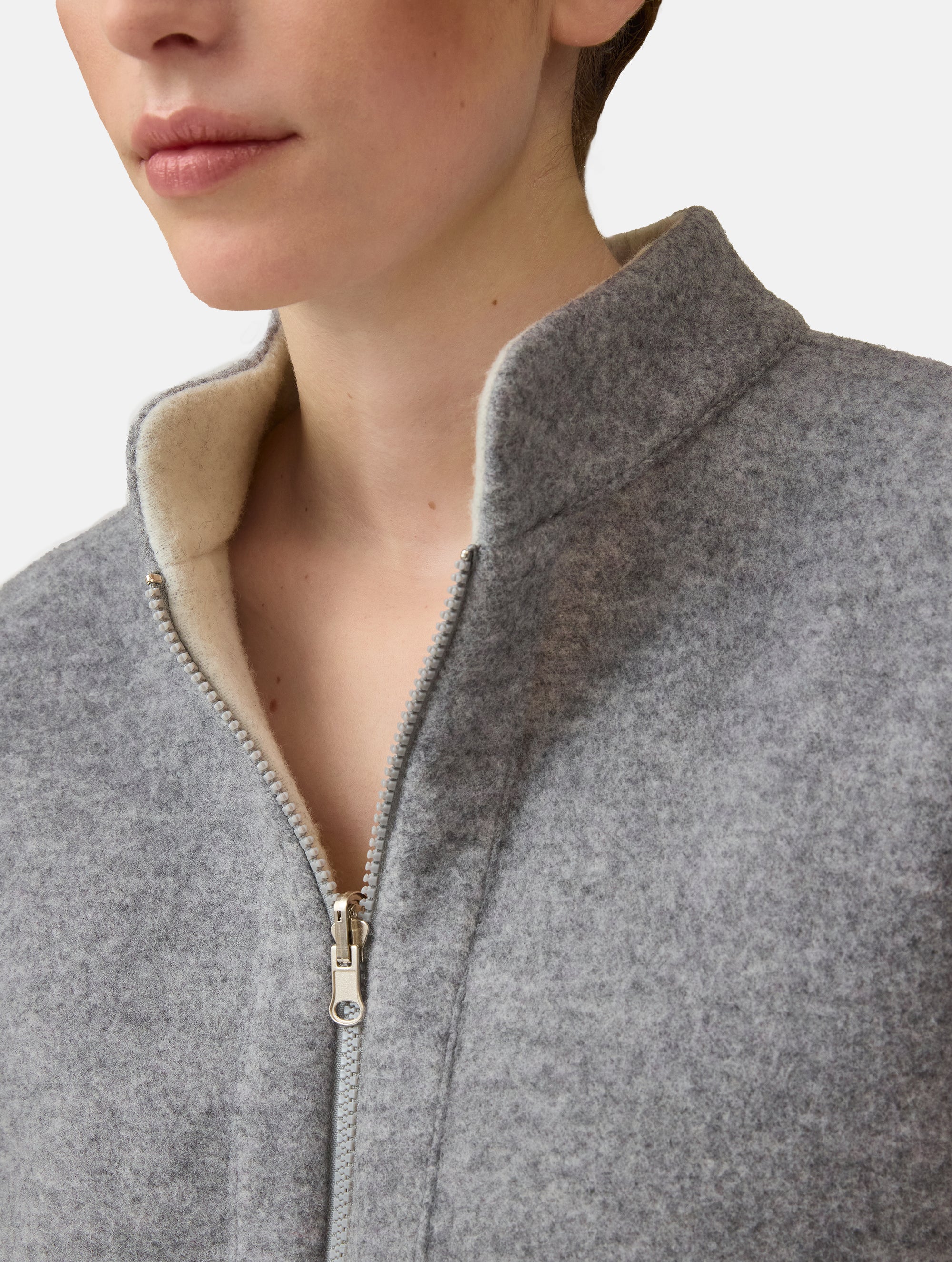 Wendbare Blousonjacke aus hochwertiger Merinowolle mit Stehkragen, Bündchen an den Ärmelenden und am Saumende, sowie seitlichen Leistentaschen auf der helleren Seite und großen aufgesetzten Taschen auf der dunkleren Seite. Dieses Modell ist Teil unserer REBORN-Linie und steht für unsere &quot;Zero-Waste-Politik&quot;, da mit Stoff aus Altbestand gefertigt.