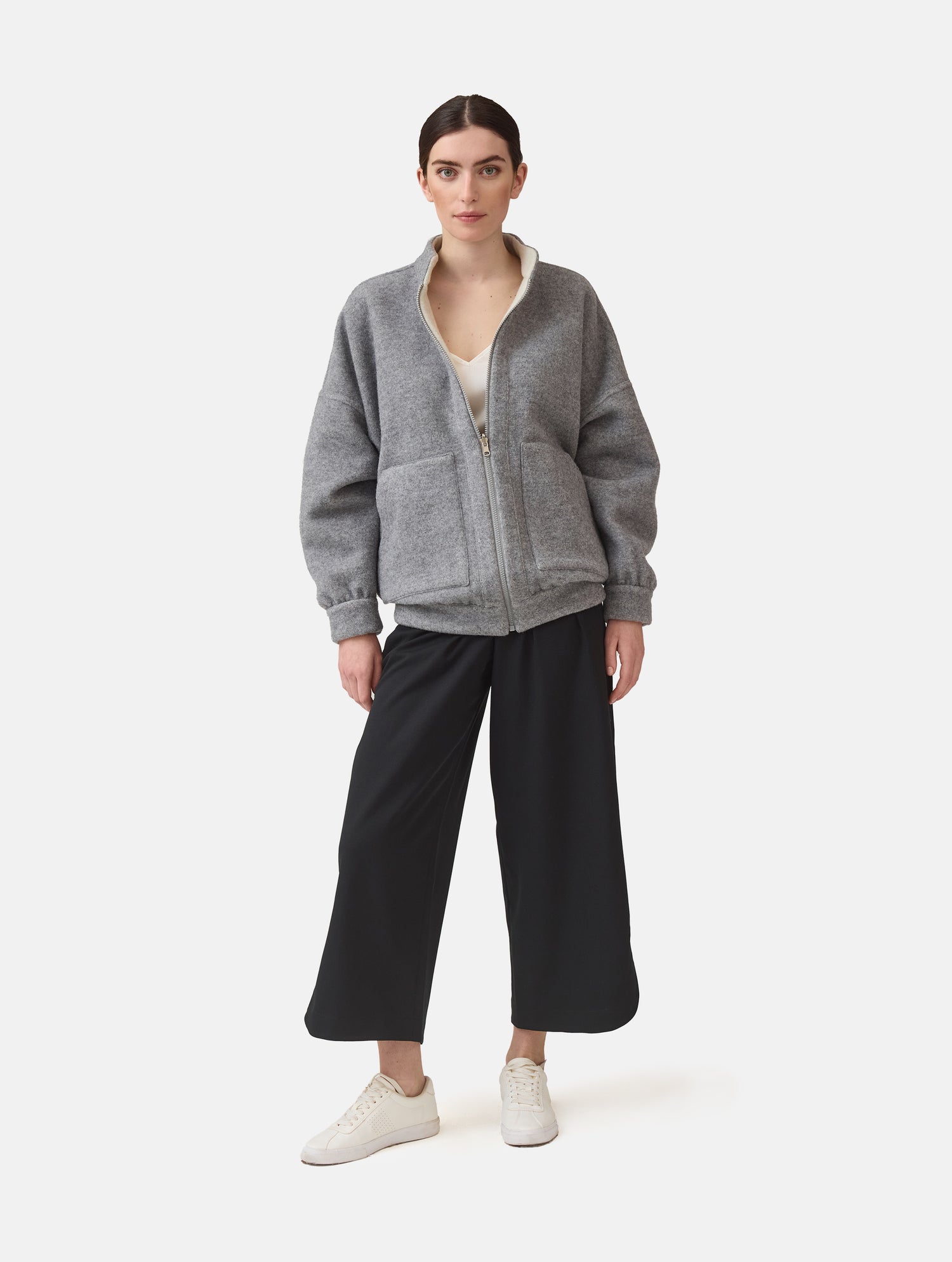 Wendbare Blousonjacke aus hochwertiger Merinowolle mit Stehkragen, Bündchen an den Ärmelenden und am Saumende, sowie seitlichen Leistentaschen auf der helleren Seite und großen aufgesetzten Taschen auf der dunkleren Seite. Dieses Modell ist Teil unserer REBORN-Linie und steht für unsere &quot;Zero-Waste-Politik&quot;, da mit Stoff aus Altbestand gefertigt.