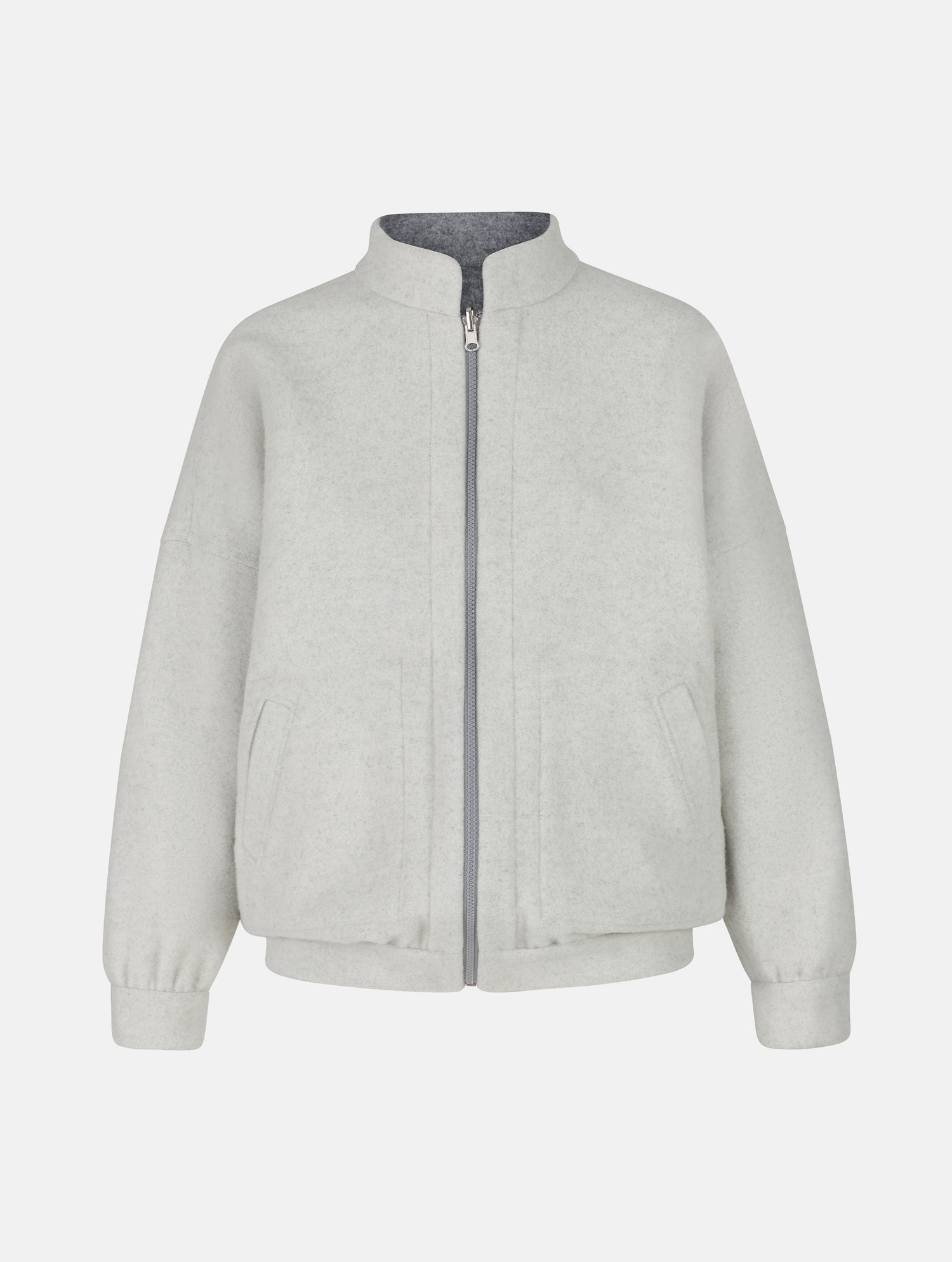 Wendbare Blousonjacke aus hochwertiger Merinowolle mit Stehkragen, Bündchen an den Ärmelenden und am Saumende, sowie seitlichen Leistentaschen auf der helleren Seite und großen aufgesetzten Taschen auf der dunkleren Seite. Dieses Modell ist Teil unserer REBORN-Linie und steht für unsere &quot;Zero-Waste-Politik&quot;, da mit Stoff aus Altbestand gefertigt.
