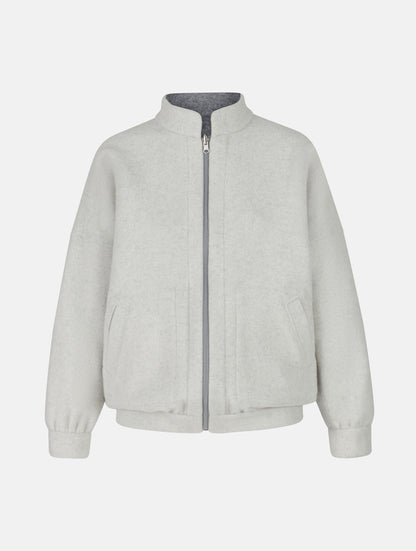 Wendbare Blousonjacke aus hochwertiger Merinowolle mit Stehkragen, Bündchen an den Ärmelenden und am Saumende, sowie seitlichen Leistentaschen auf der helleren Seite und großen aufgesetzten Taschen auf der dunkleren Seite. Dieses Modell ist Teil unserer REBORN-Linie und steht für unsere &quot;Zero-Waste-Politik&quot;, da mit Stoff aus Altbestand gefertigt.