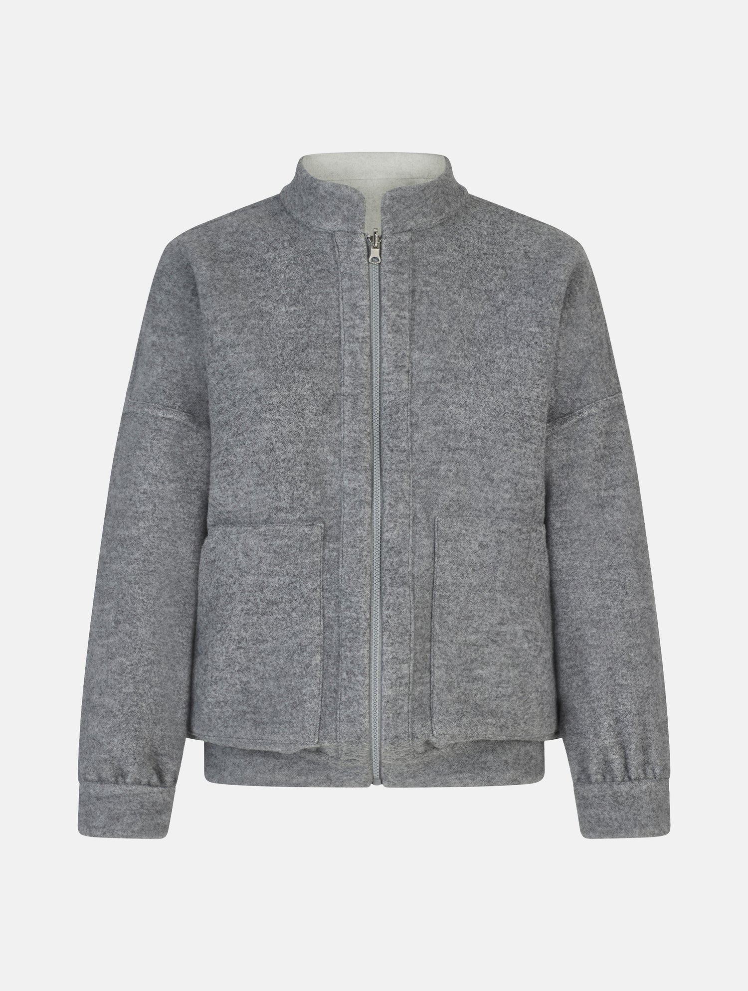 Wendbare Blousonjacke aus hochwertiger Merinowolle mit Stehkragen, Bündchen an den Ärmelenden und am Saumende, sowie seitlichen Leistentaschen auf der helleren Seite und großen aufgesetzten Taschen auf der dunkleren Seite. Dieses Modell ist Teil unserer REBORN-Linie und steht für unsere &quot;Zero-Waste-Politik&quot;, da mit Stoff aus Altbestand gefertigt.
