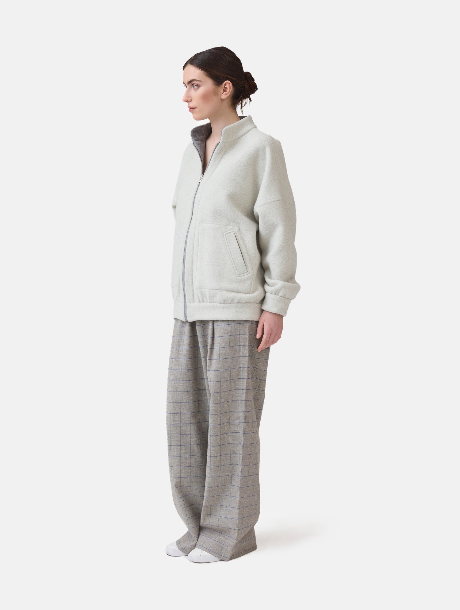 Wendbare Blousonjacke aus hochwertiger Merinowolle mit Stehkragen, Bündchen an den Ärmelenden und am Saumende, sowie seitlichen Leistentaschen auf der helleren Seite und großen aufgesetzten Taschen auf der dunkleren Seite. Dieses Modell ist Teil unserer REBORN-Linie und steht für unsere &quot;Zero-Waste-Politik&quot;, da mit Stoff aus Altbestand gefertigt.