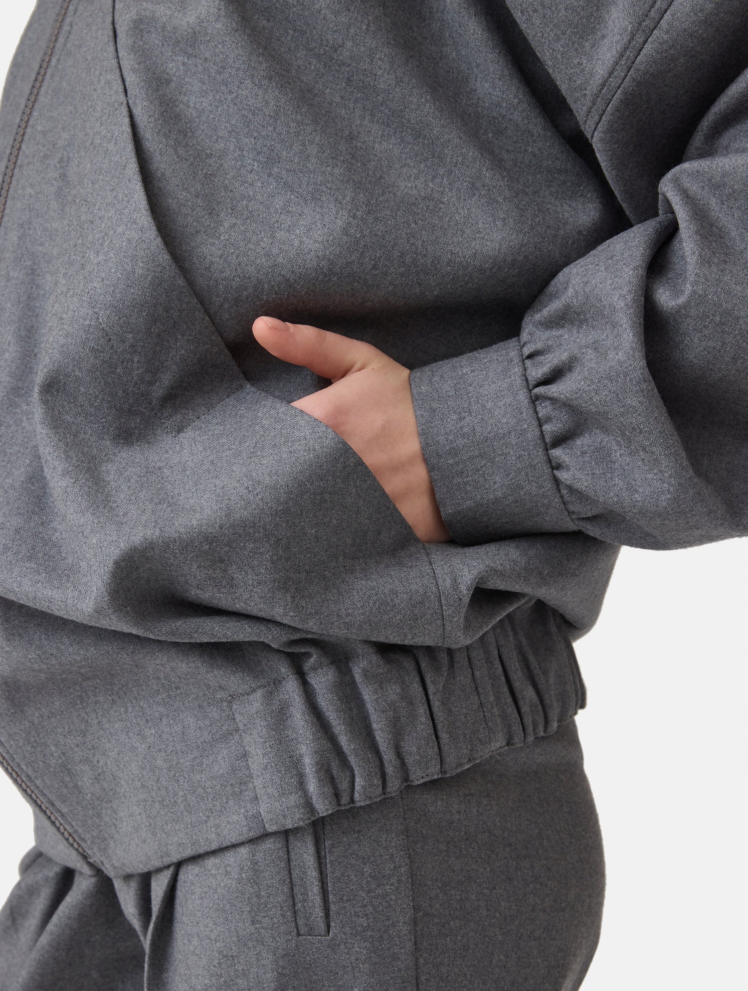 Locker geschnittene Blousonjacke mit Kapuze und Reißverschluss, sowie dreiecksförmiger Kängurutasche im Vorderteil und elastischem Bündchen am Saumende. Dieses Modell ist Teil unserer REBORN-Linie und steht für unsere &quot;Zero-Waste-Politik&quot;, da mit Stoff aus Altbestand gefertigt.