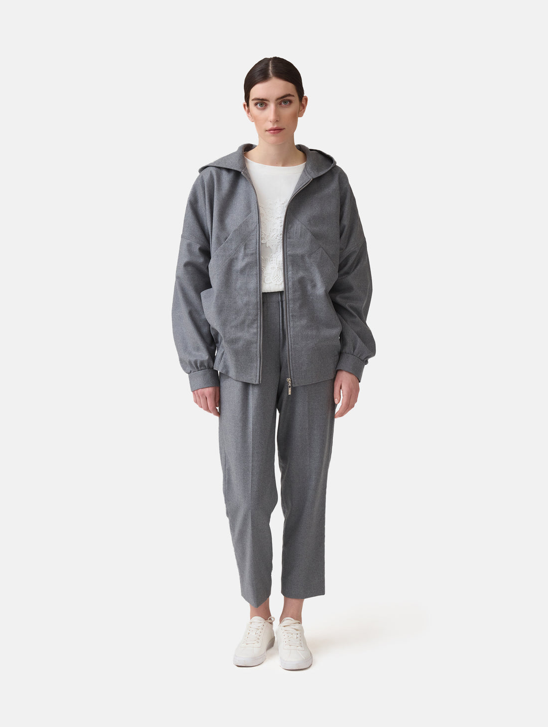 Locker geschnittene Blousonjacke mit Kapuze und Reißverschluss, sowie dreiecksförmiger Kängurutasche im Vorderteil und elastischem Bündchen am Saumende. Dieses Modell ist Teil unserer REBORN-Linie und steht für unsere &quot;Zero-Waste-Politik&quot;, da mit Stoff aus Altbestand gefertigt.