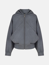 Locker geschnittene Blousonjacke mit Kapuze und Reißverschluss, sowie dreiecksförmiger Kängurutasche im Vorderteil und elastischem Bündchen am Saumende. Dieses Modell ist Teil unserer REBORN-Linie und steht für unsere "Zero-Waste-Politik", da mit Stoff aus Altbestand gefertigt.