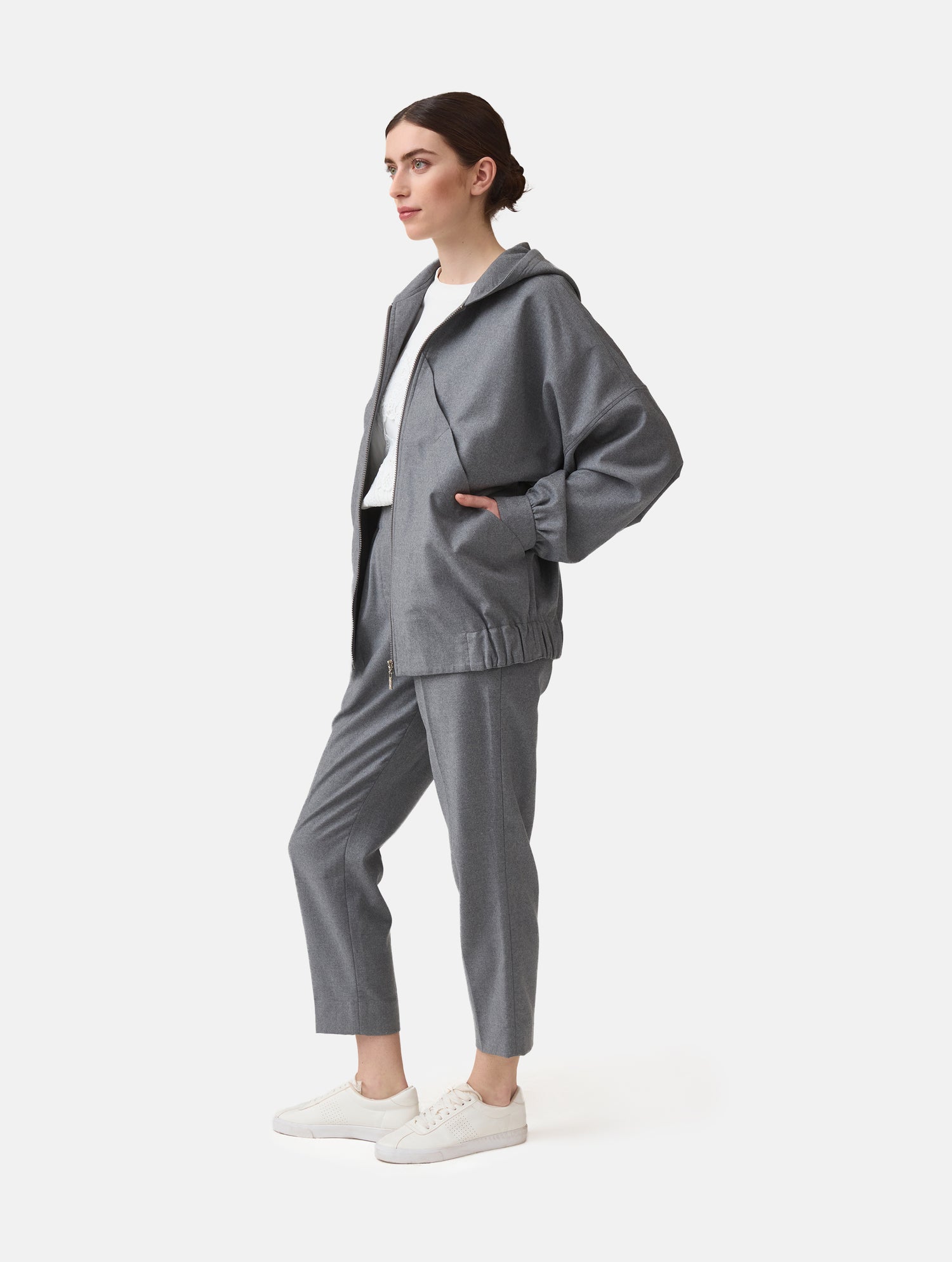 Locker geschnittene Blousonjacke mit Kapuze und Reißverschluss, sowie dreiecksförmiger Kängurutasche im Vorderteil und elastischem Bündchen am Saumende. Dieses Modell ist Teil unserer REBORN-Linie und steht für unsere &quot;Zero-Waste-Politik&quot;, da mit Stoff aus Altbestand gefertigt.