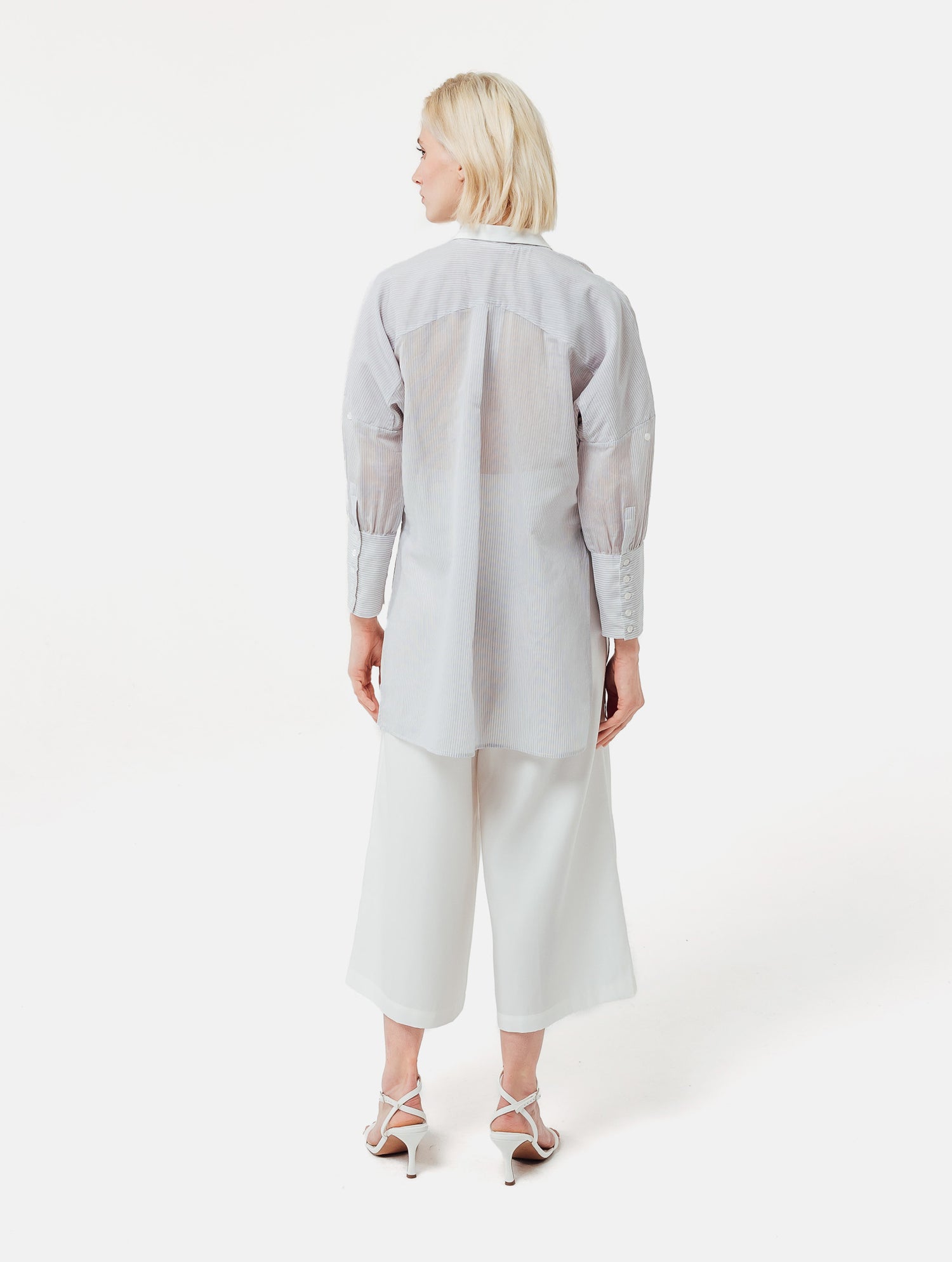 Gestreifte Oversized-Bluse mit hohen Seitenschlitzen, breiten Manschetten und geschwungener Rückenpasse.