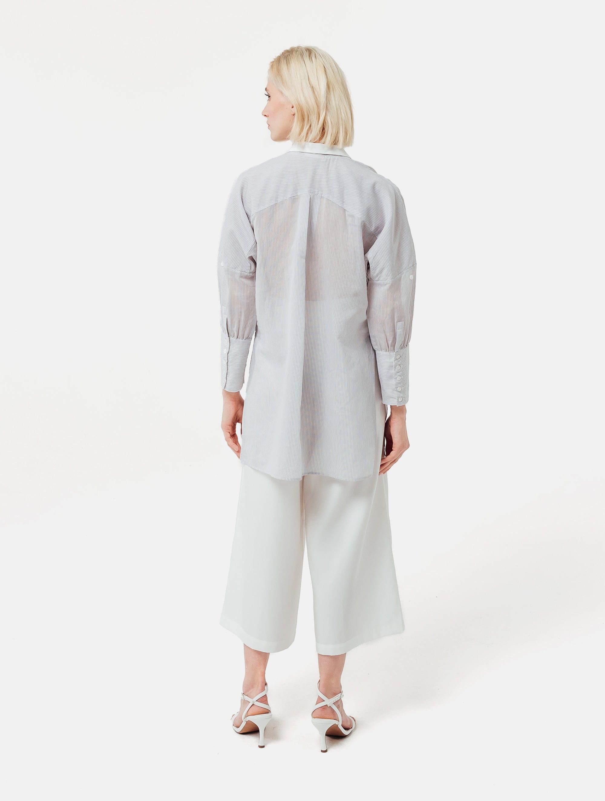 Gestreifte Oversized-Bluse mit hohen Seitenschlitzen, breiten Manschetten und geschwungener Rückenpasse.